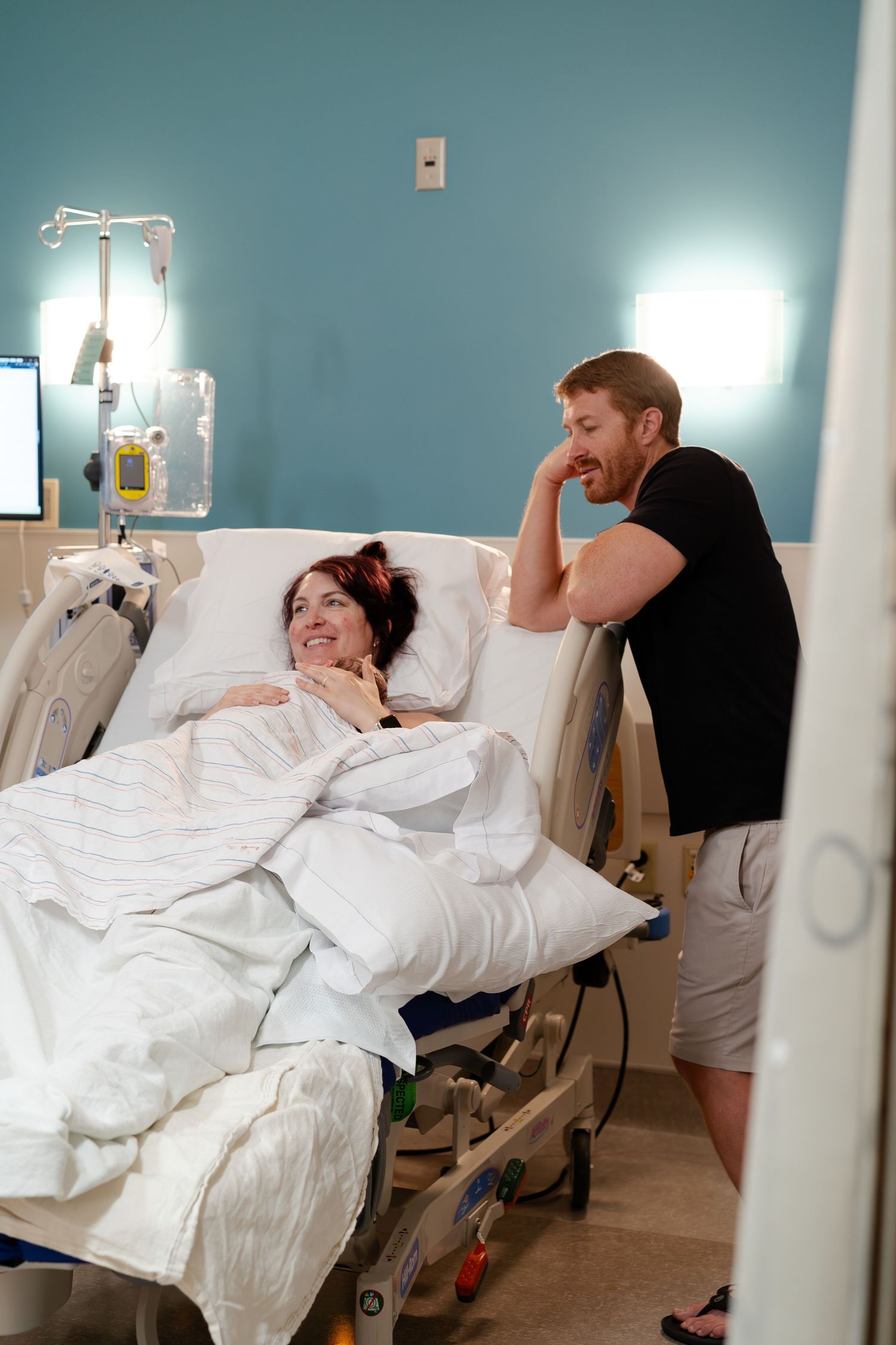 Emotional first family embrace immediately after delivery photographed with permission in a hospital setting.