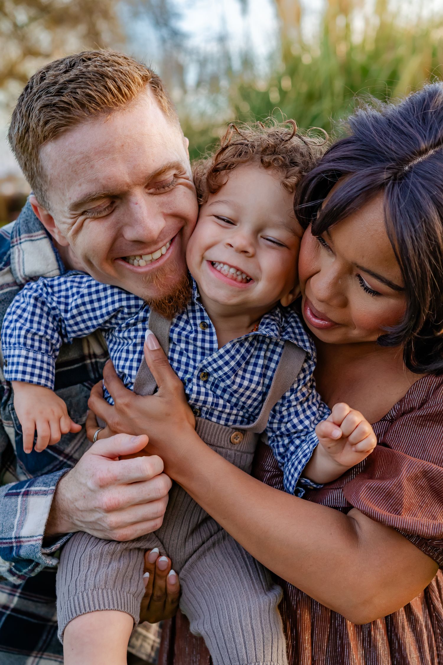 Family of 3 squeeze faces together during a playful photoshoot in Oakdale, CA