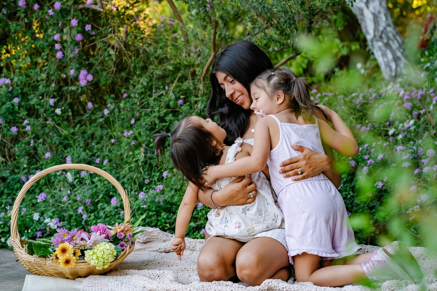 faceless kid photo with their mom in a green and flower filled scene at golden hour in Turlock, California