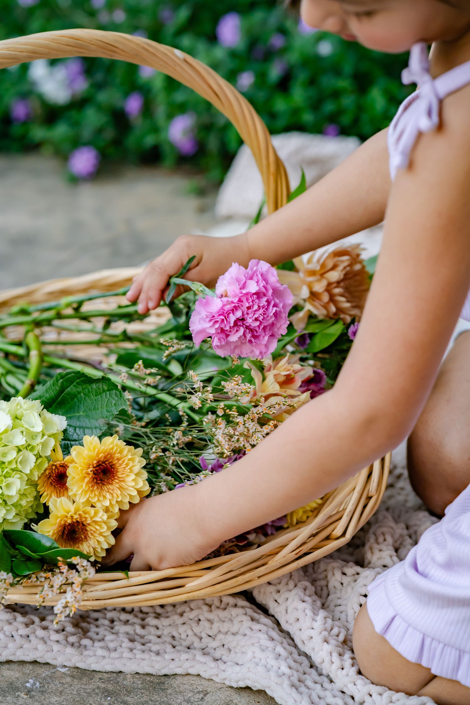 daughter looking at flowers in a basket during a mothers day photo session