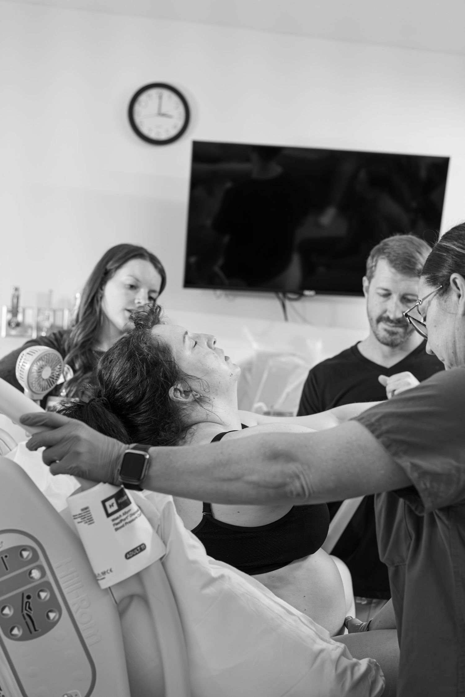 Woman labors while husband and doula help