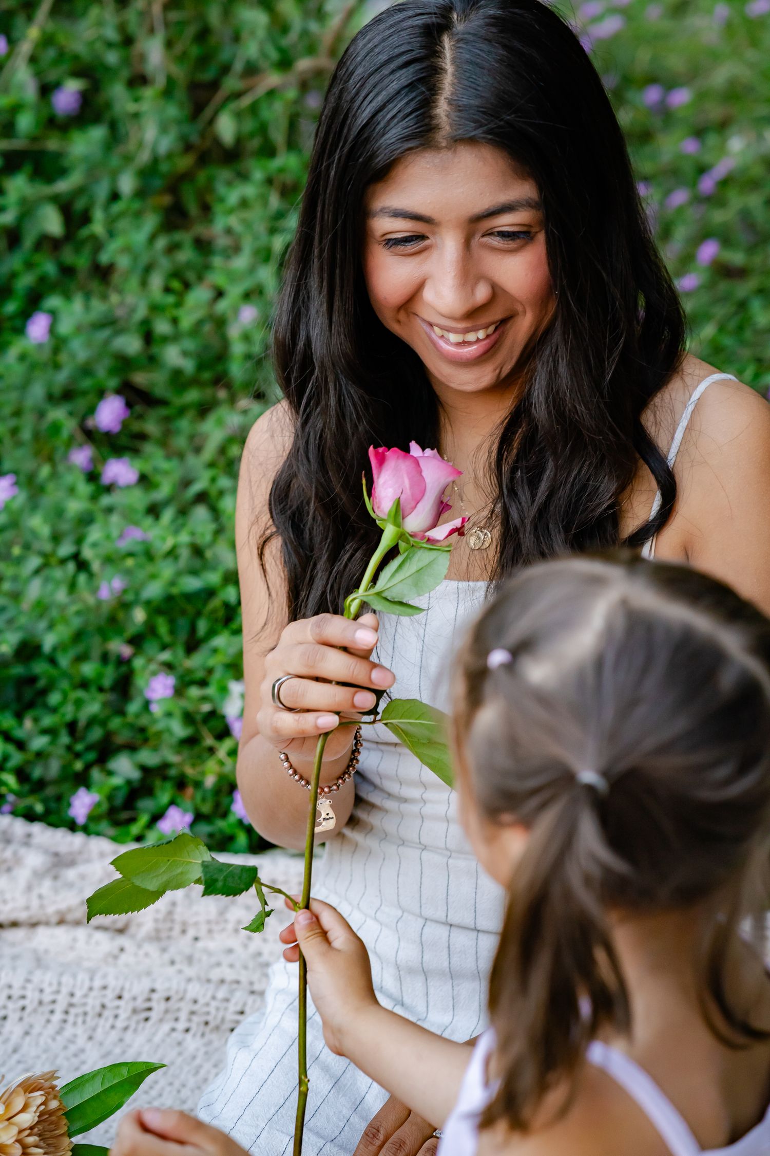 daughter giving her mom a rose for mothers day