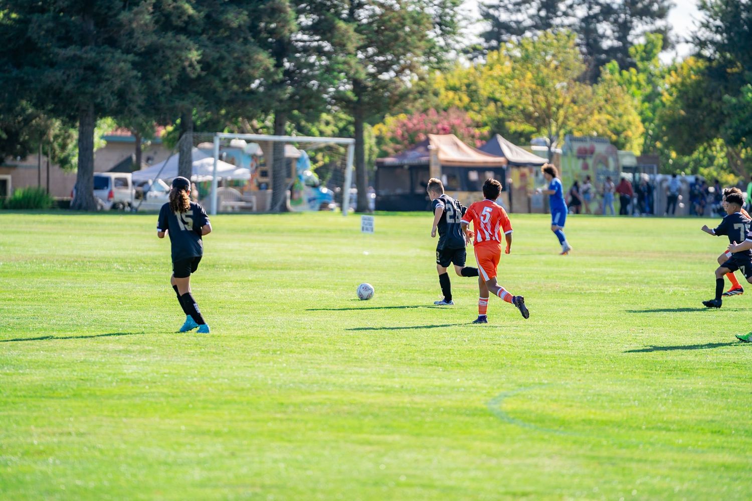 Soccer player dribbling past defenders during a competitive youth match photographed in Turlock.