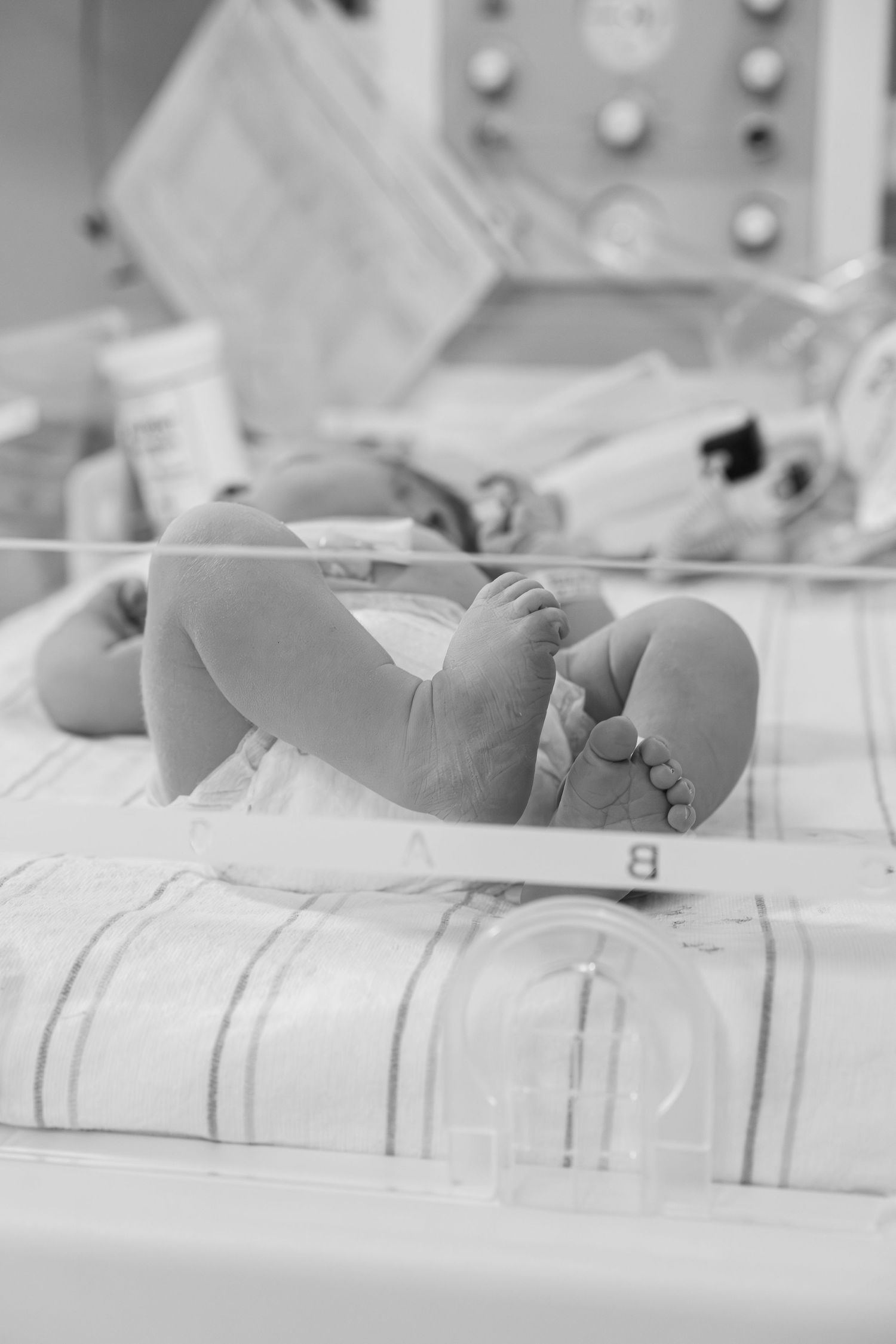 Detail photo of newborn hospital bracelet, tiny toes, and swaddle blanket captured during a Fresh 48 session.