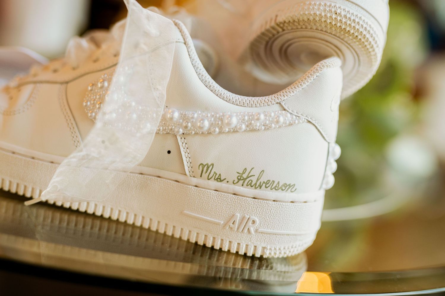 Close-up of white bridal shoes with decorative details.