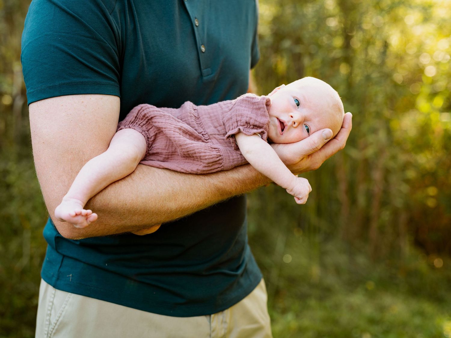 A series of photos showing hands cradling and holding a small newborn baby against a sunlit outdoor background.