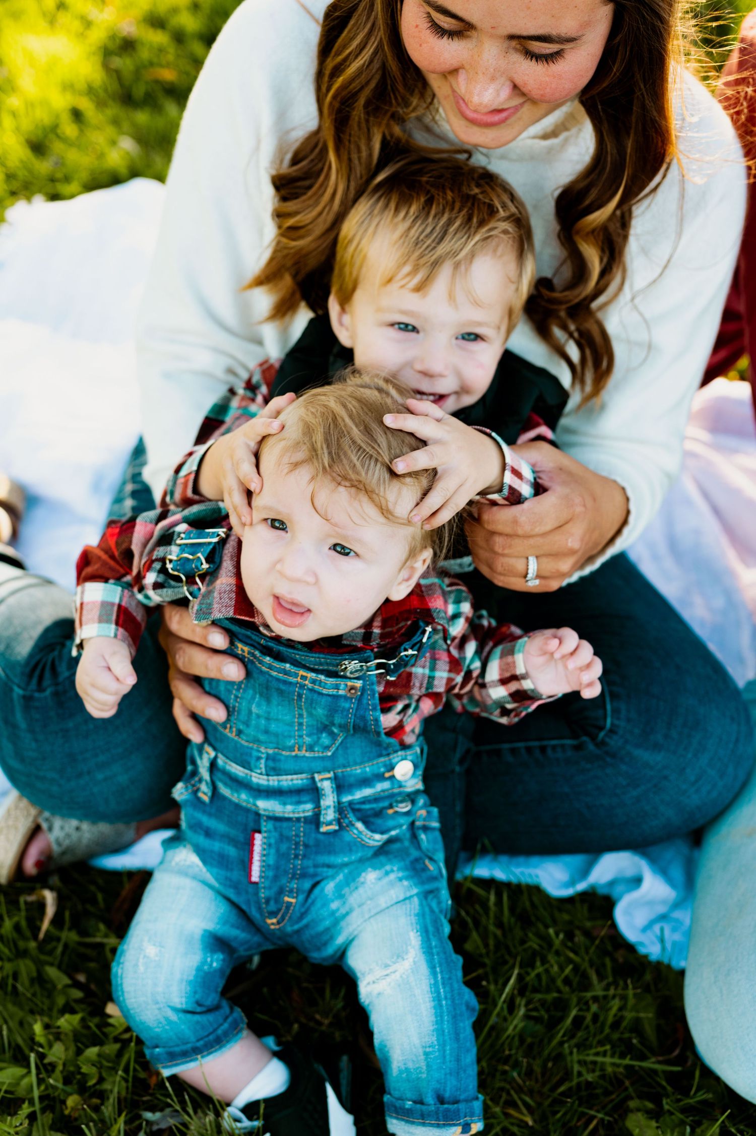 A heartwarming outdoor family moment with denim overalls and plaid shirts on a sunny day.