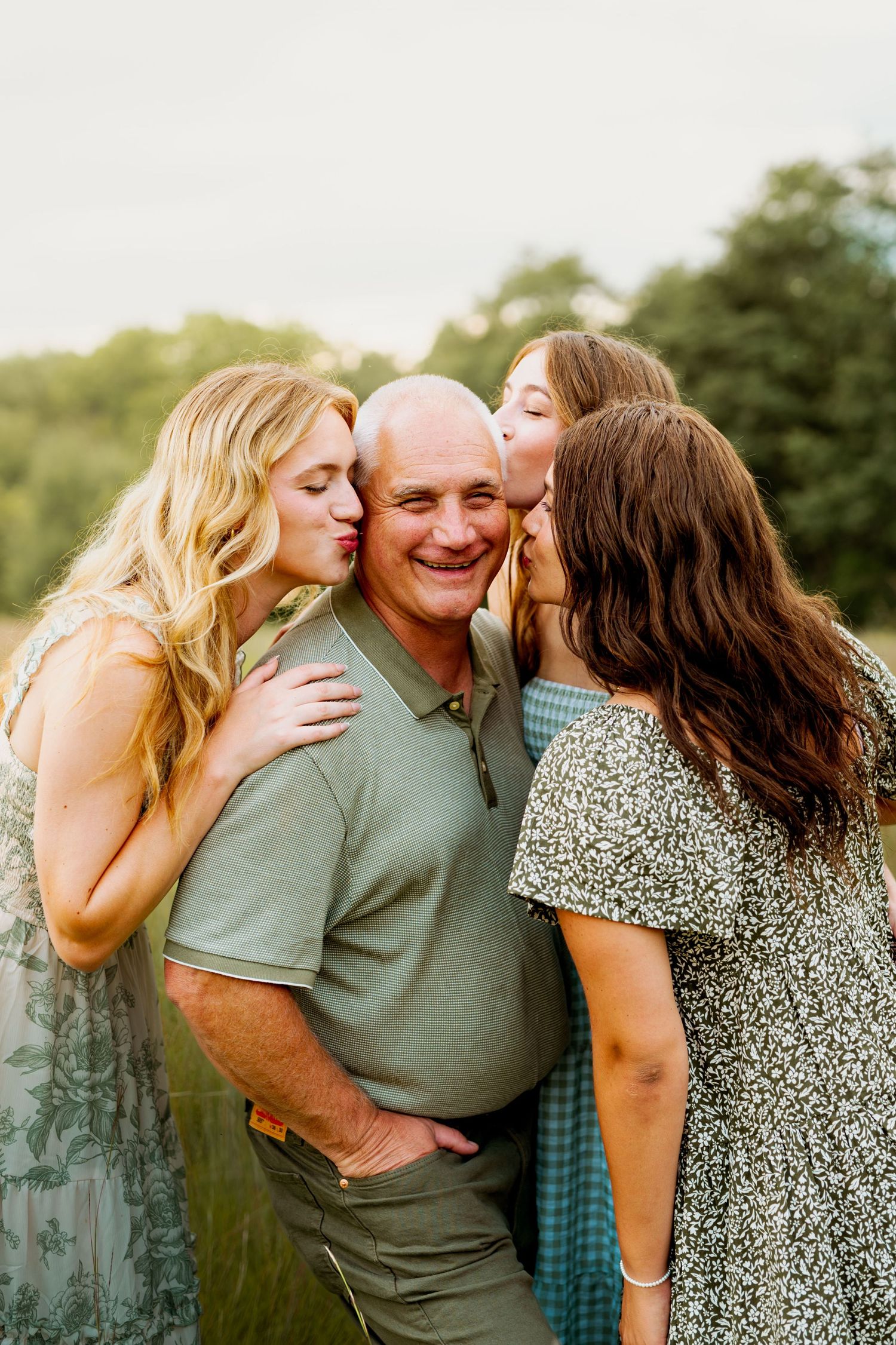 A candid outdoor photoshoot showing tender moments between family members in matching green and floral attire.