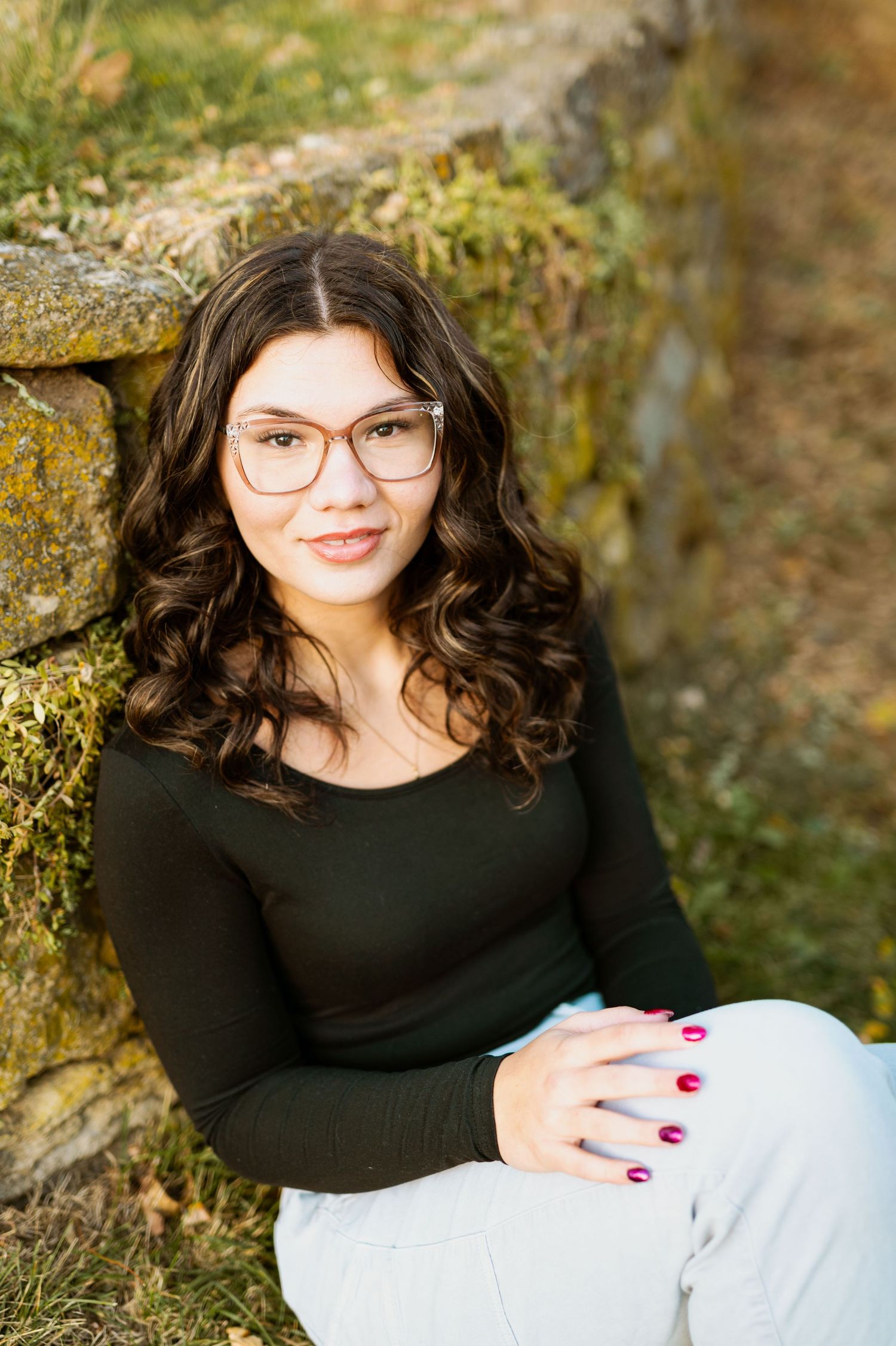 Relaxed portrait session showcasing casual style against a natural stone backdrop.