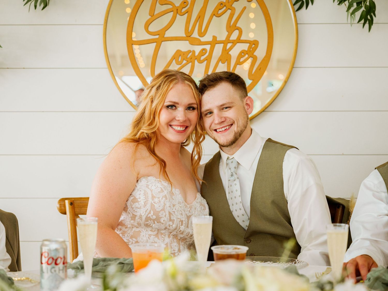 A romantic wedding reception scene with a decorative circular sign and elegant table settings.