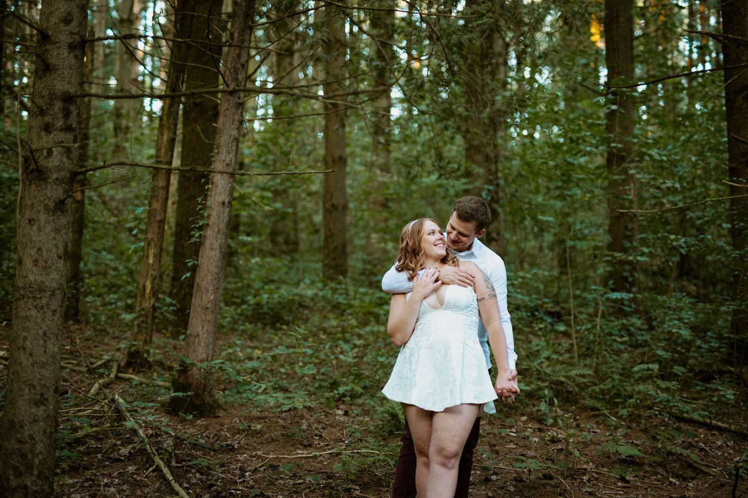 A romantic photoshoot in a lush green forest setting.