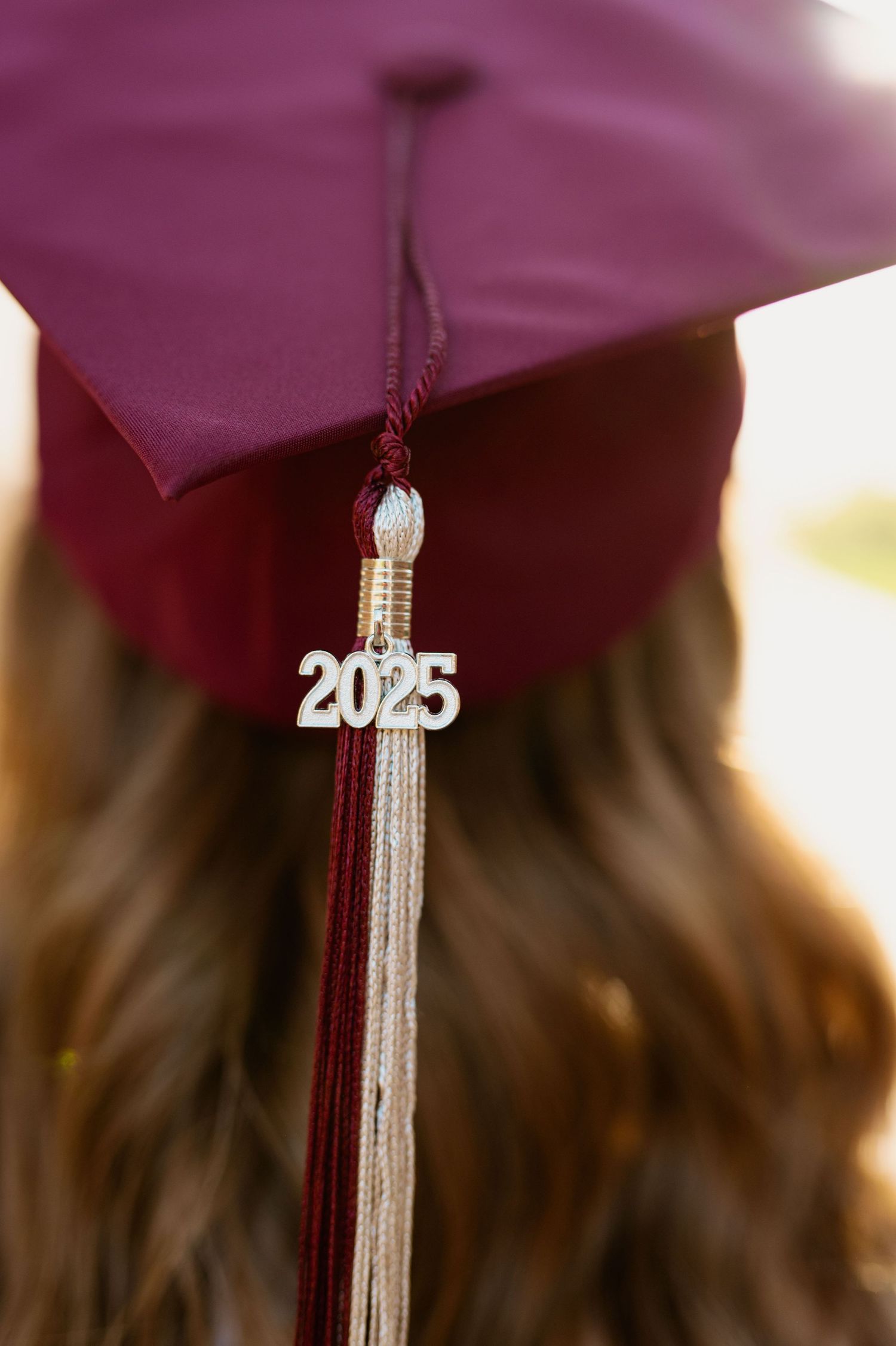 Class of 2023 graduation tassel detail against maroon cap background.