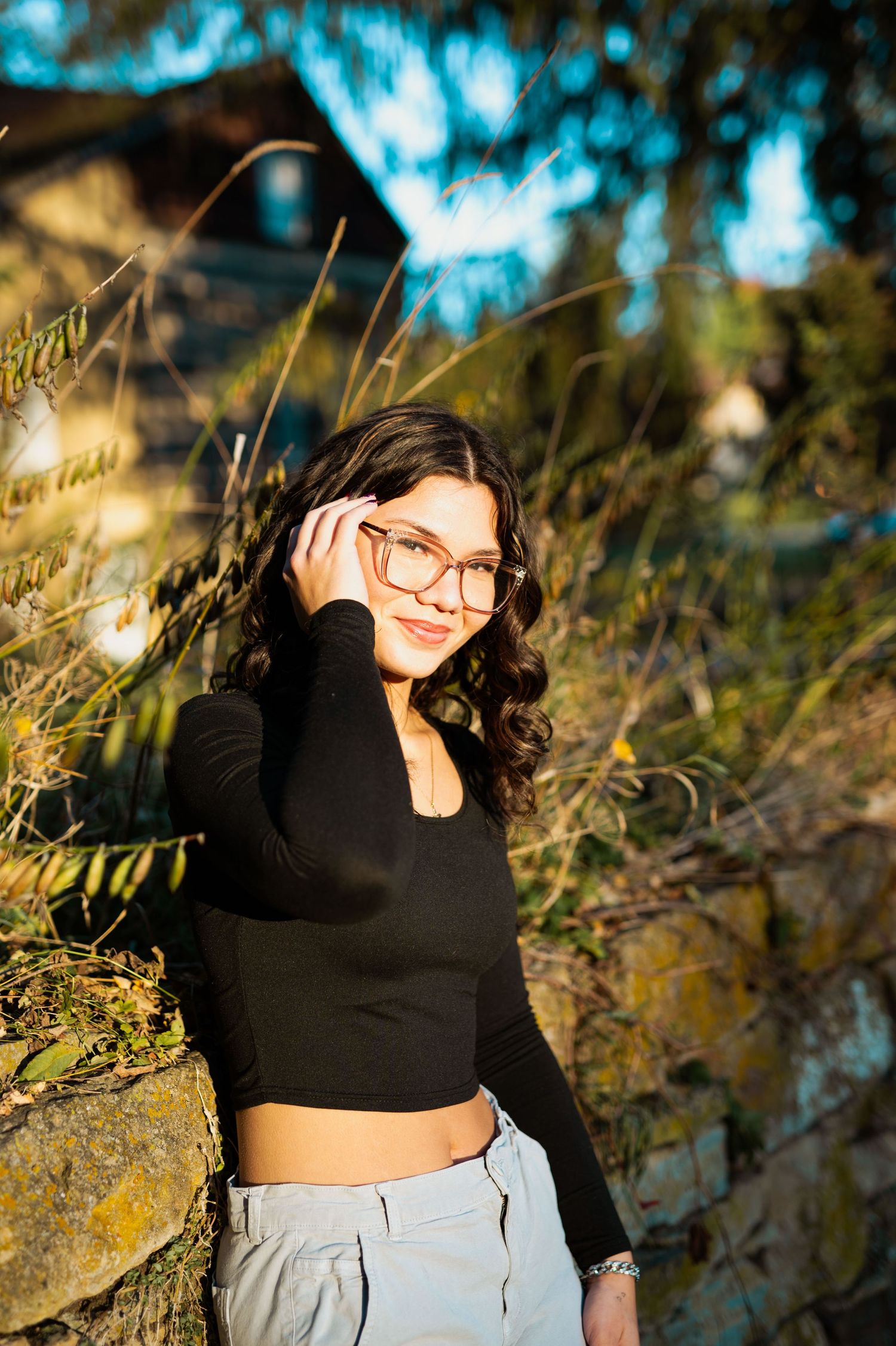 Stylish outdoor photoshoot featuring casual wear against a textured stone background.