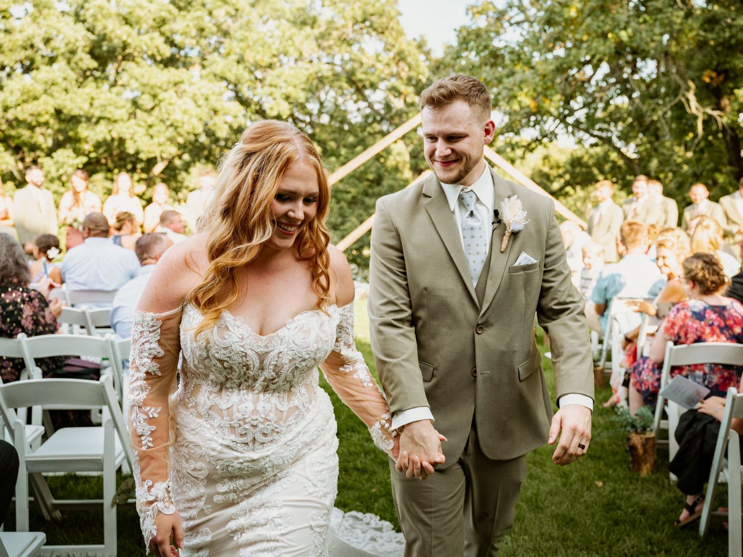Joyful wedding celebration outdoors with lush greenery and natural sunlight creating a romantic atmosphere.