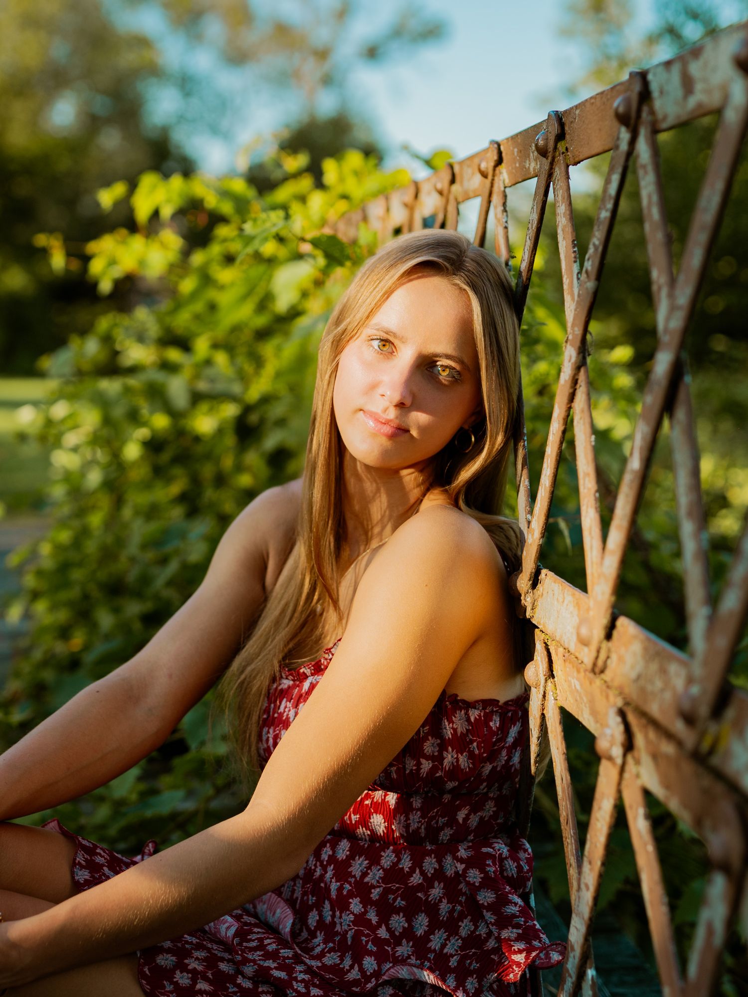 A series of artistic outdoor portraits taken in warm sunlight with wooden lattice creating diagonal shadows.