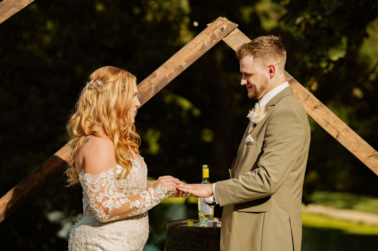 A wedding ceremony moment captured in golden sunlight with rustic wooden details.