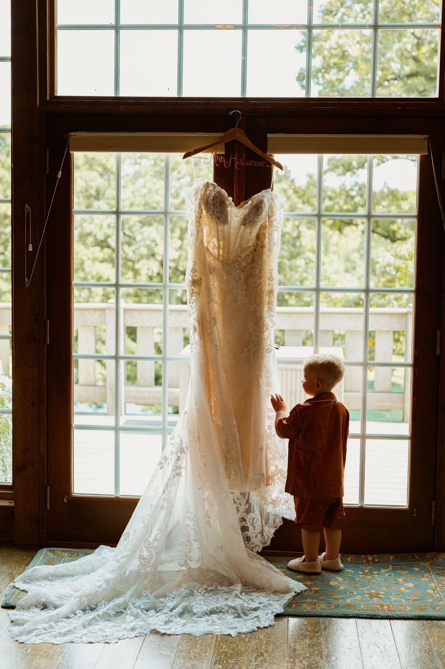 Wedding dresses displayed in silhouette against bright windows.