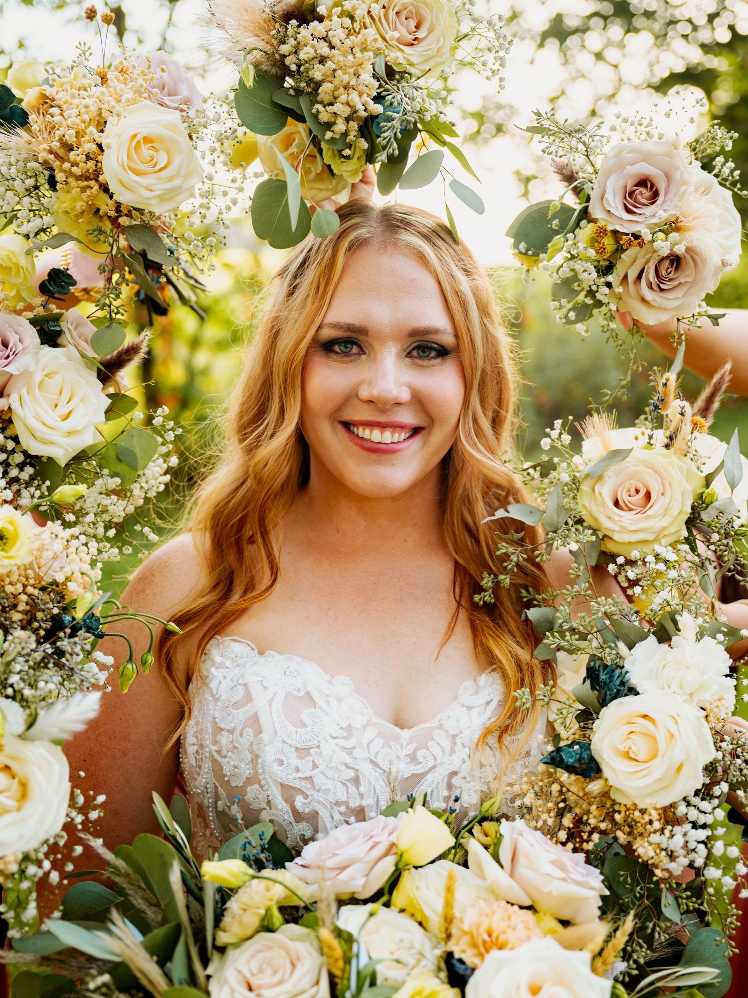 Elegant bridal bouquet featuring cream roses, delicate baby's breath, and greenery in soft natural lighting.