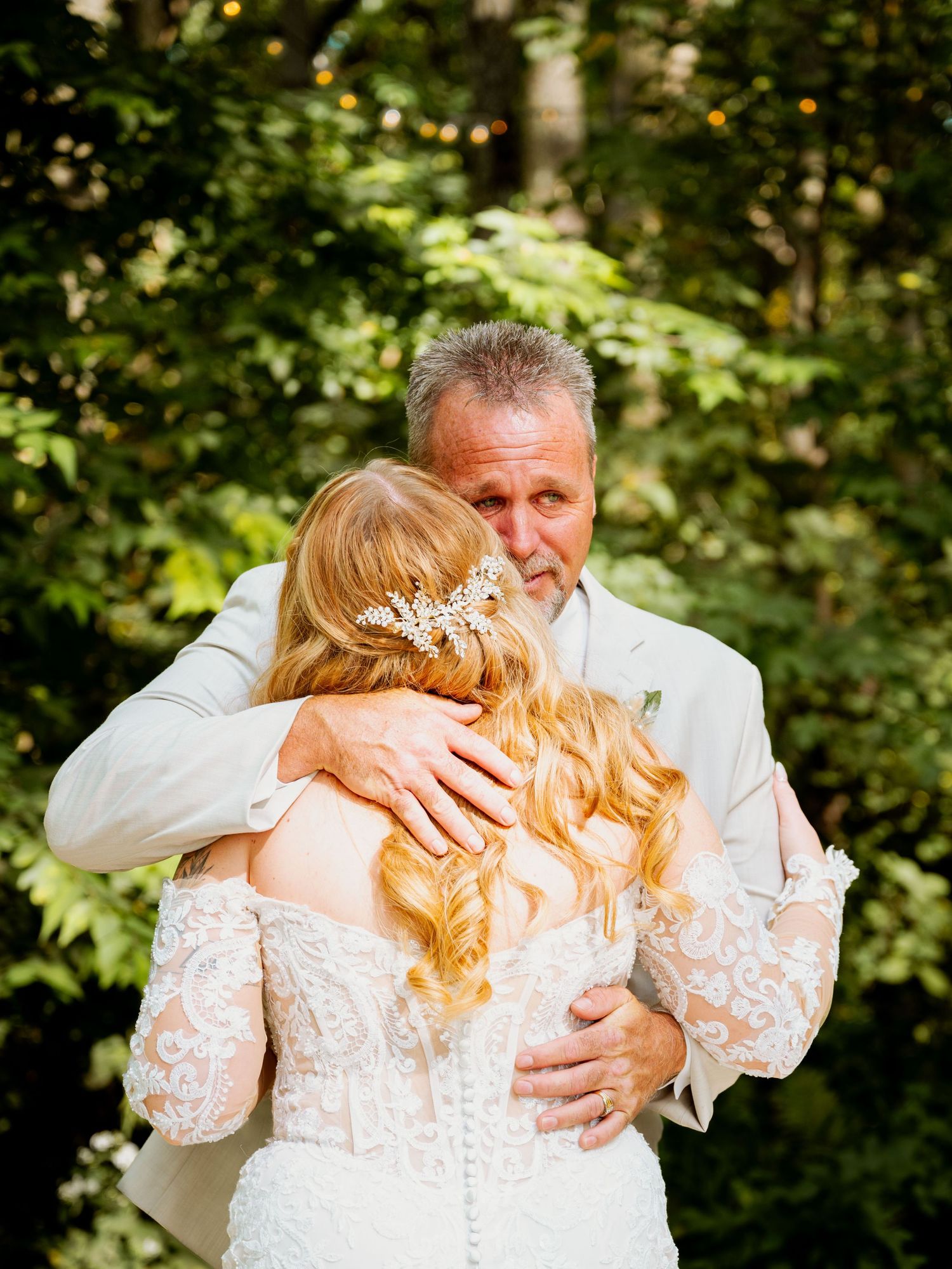 Emotional first look moment between bride and groom in a lush garden setting.
