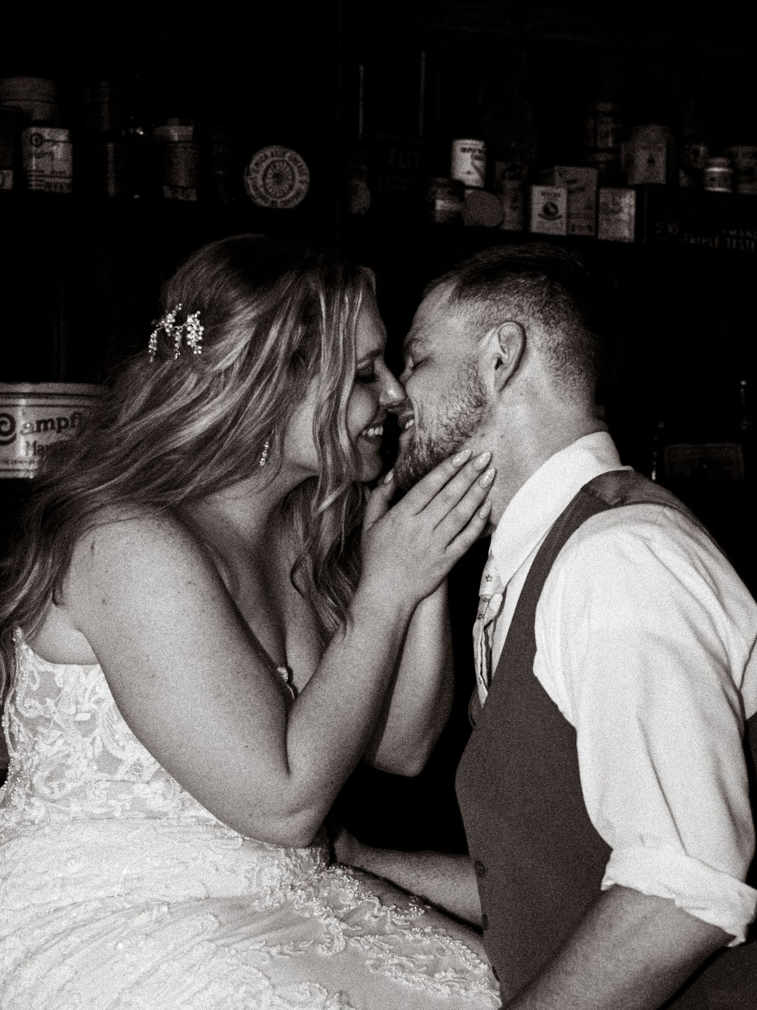 An intimate black and white wedding moment captured in a dimly lit indoor setting.