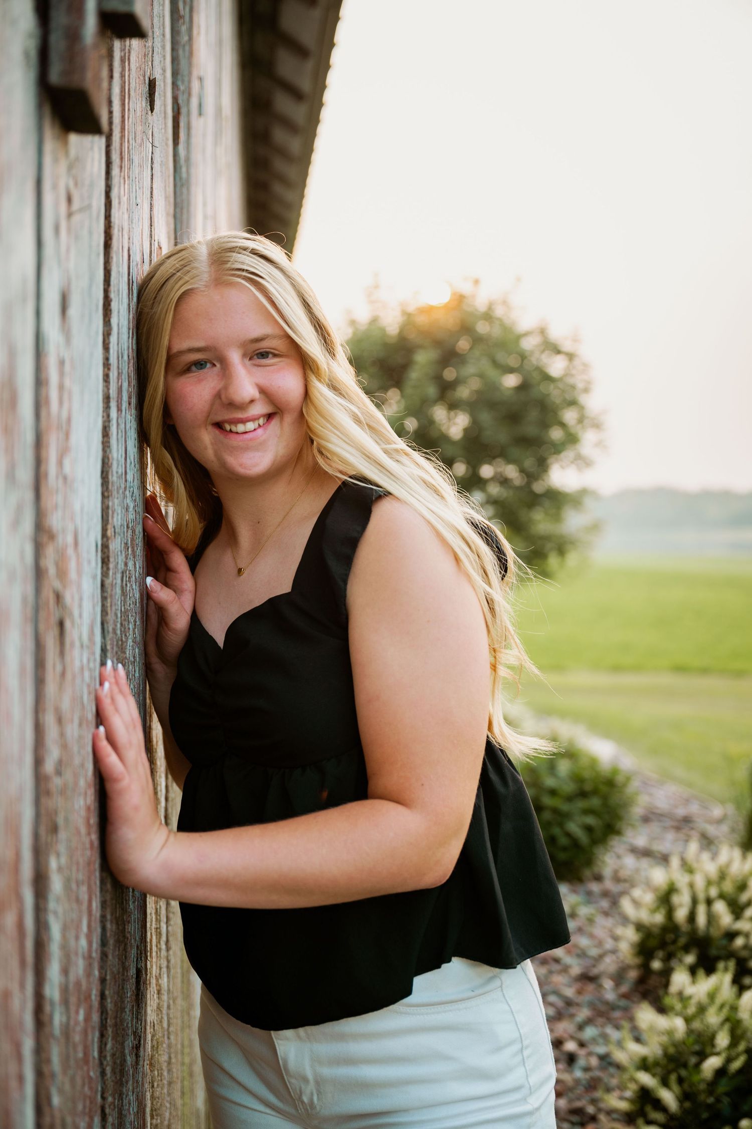 Three outdoor portrait photos at sunset against rustic wooden posts with green scenery in the background.