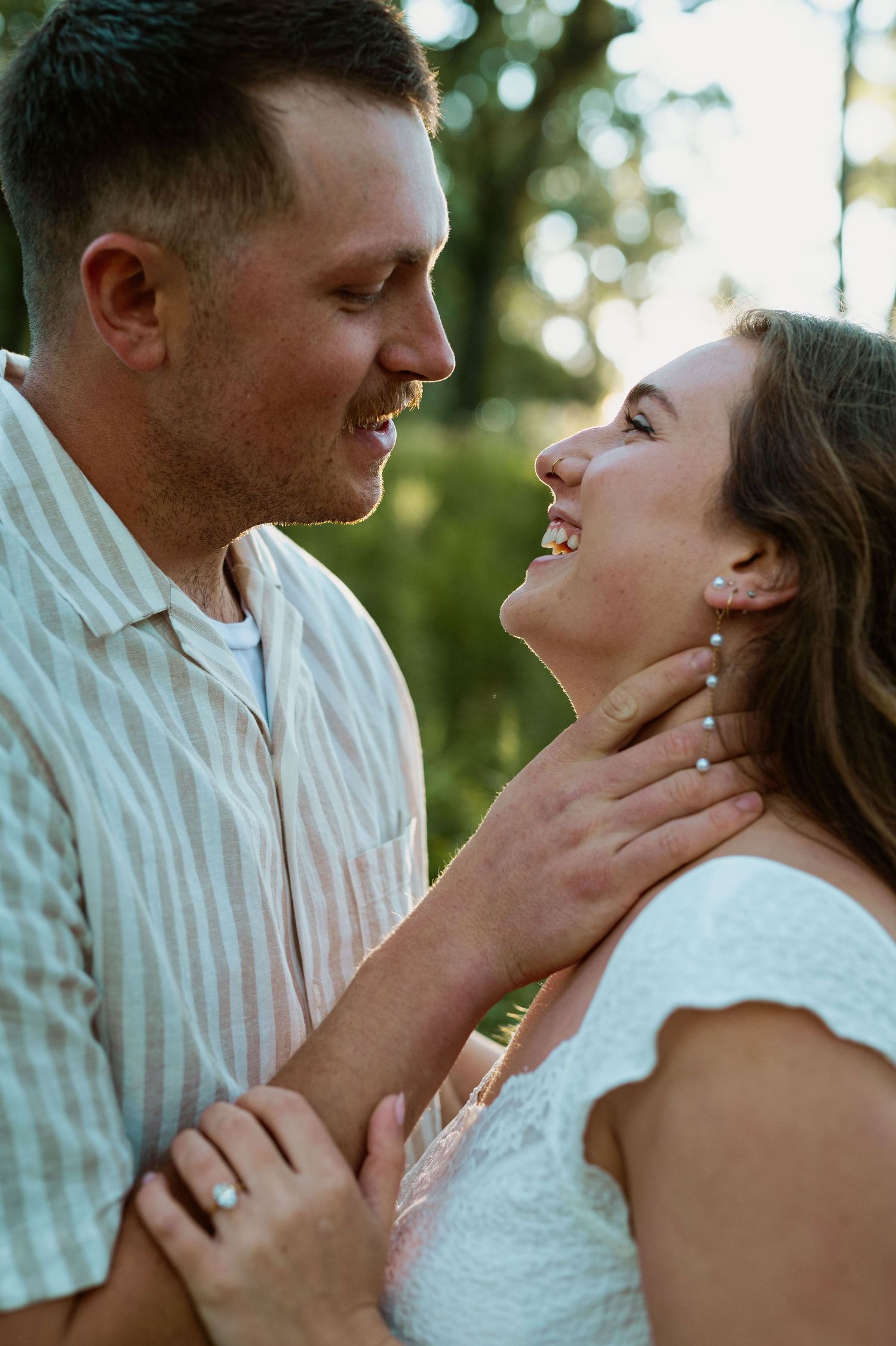Close up of couple laughing together in intimate moment outdoors.
