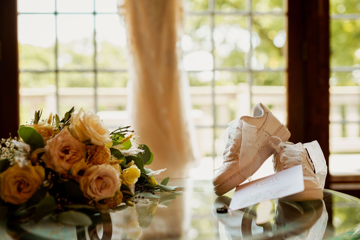 Romantic wedding table decor with peach and cream floral arrangements in natural light setting.