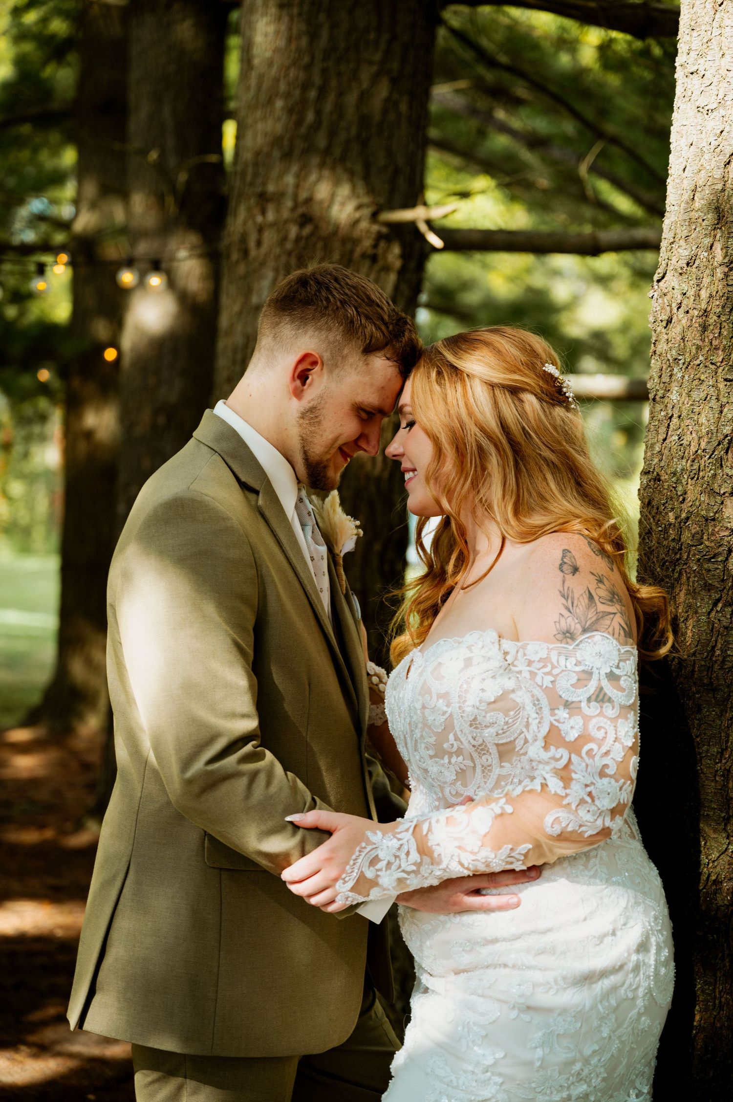 A romantic moment between newlyweds sharing an intimate embrace in a wooded setting.