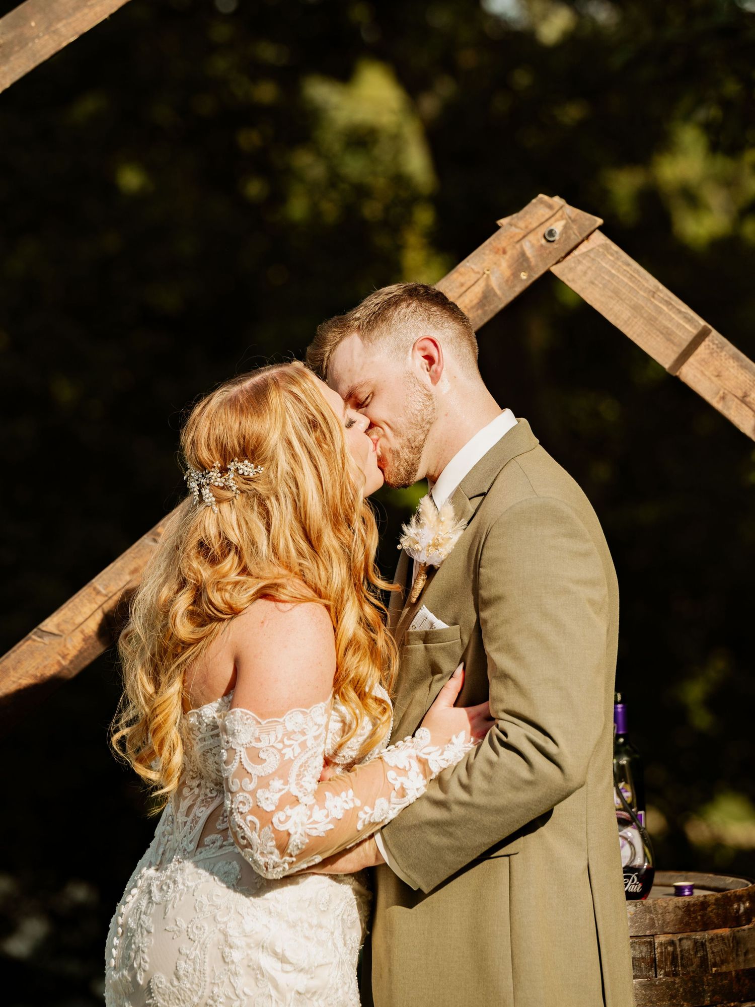 A romantic wedding moment captured against rustic wooden beams.