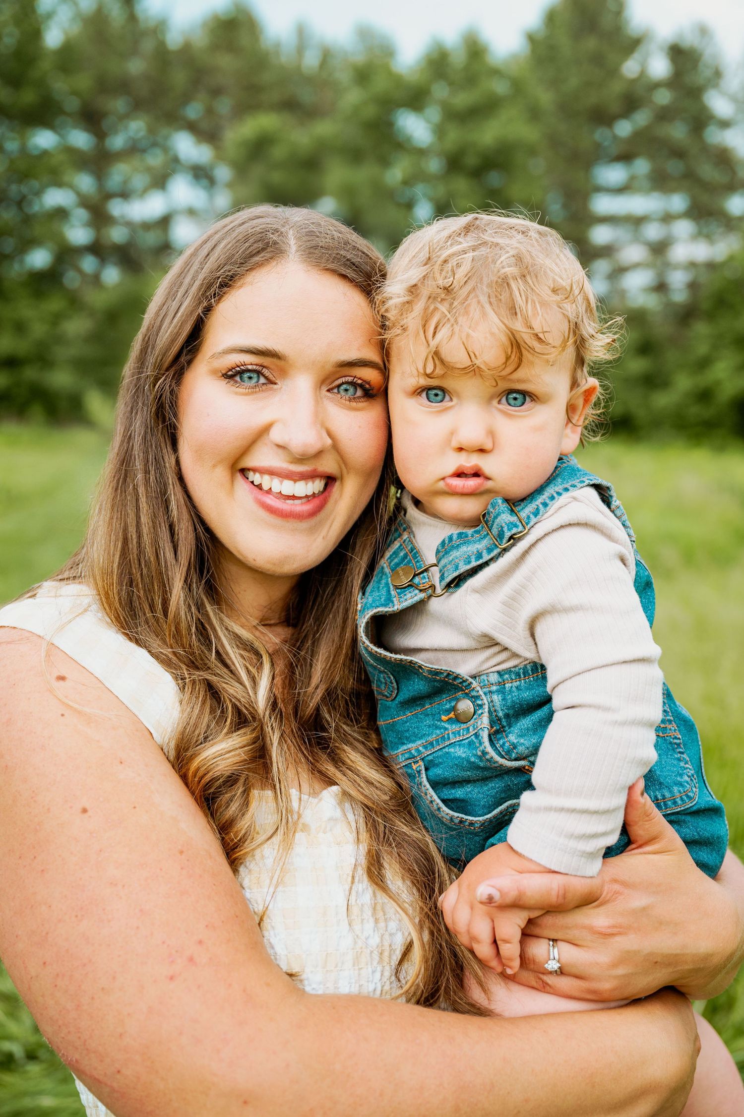 A series of outdoor family portraits showing a loving embrace between parent and child in a grassy field with pine trees.