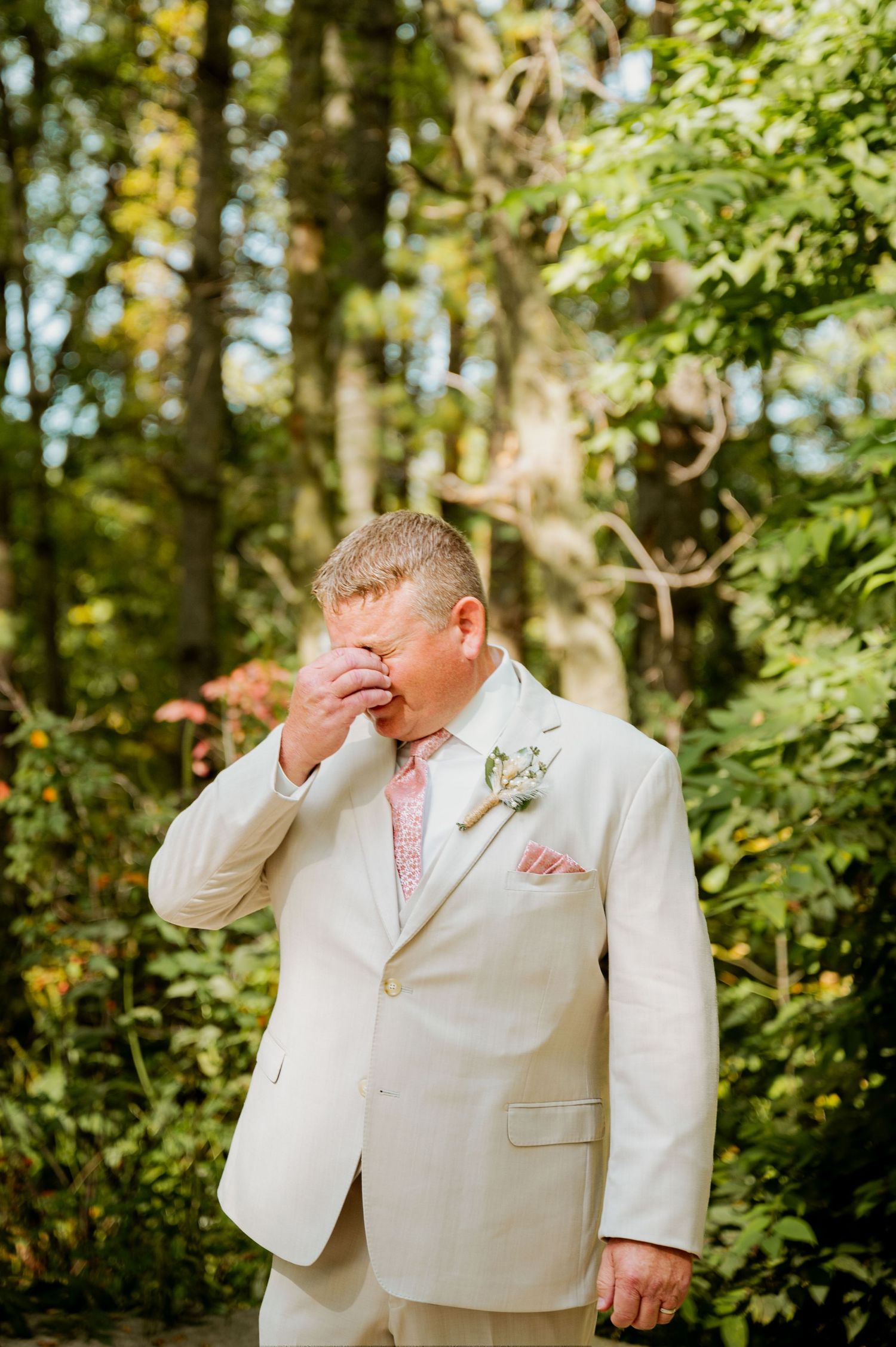 Wedding moment captured in wooded setting with emotional reactions.