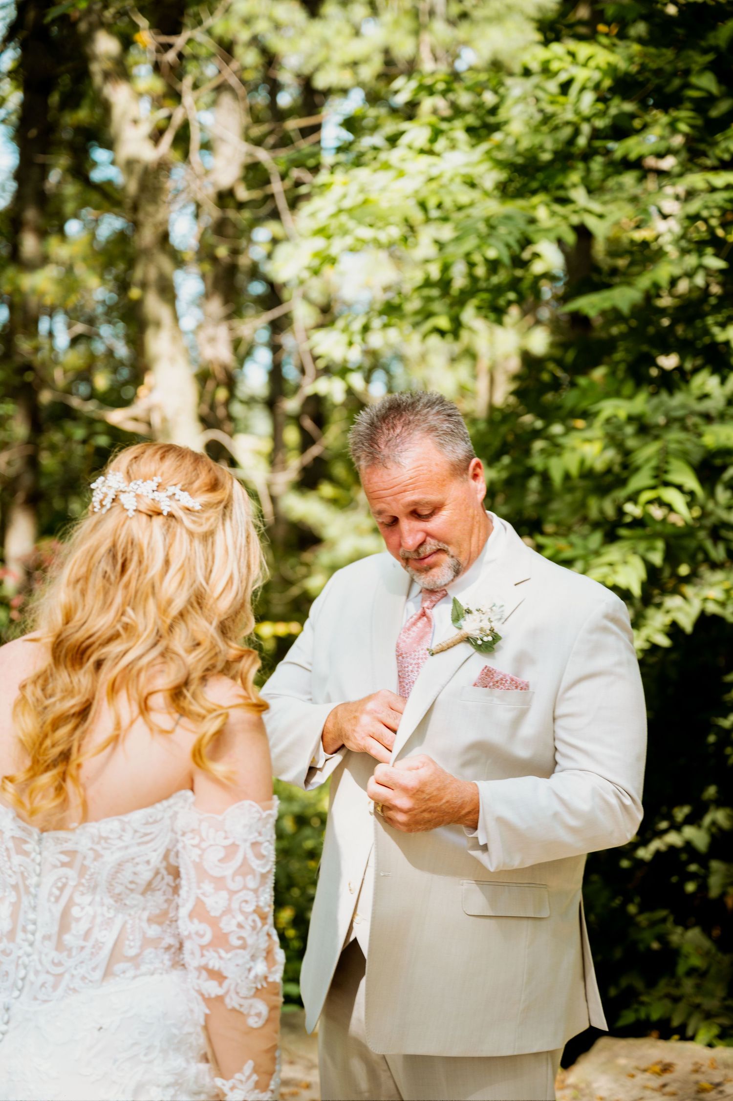 Emotional first look moment between newlyweds in a lush garden setting.