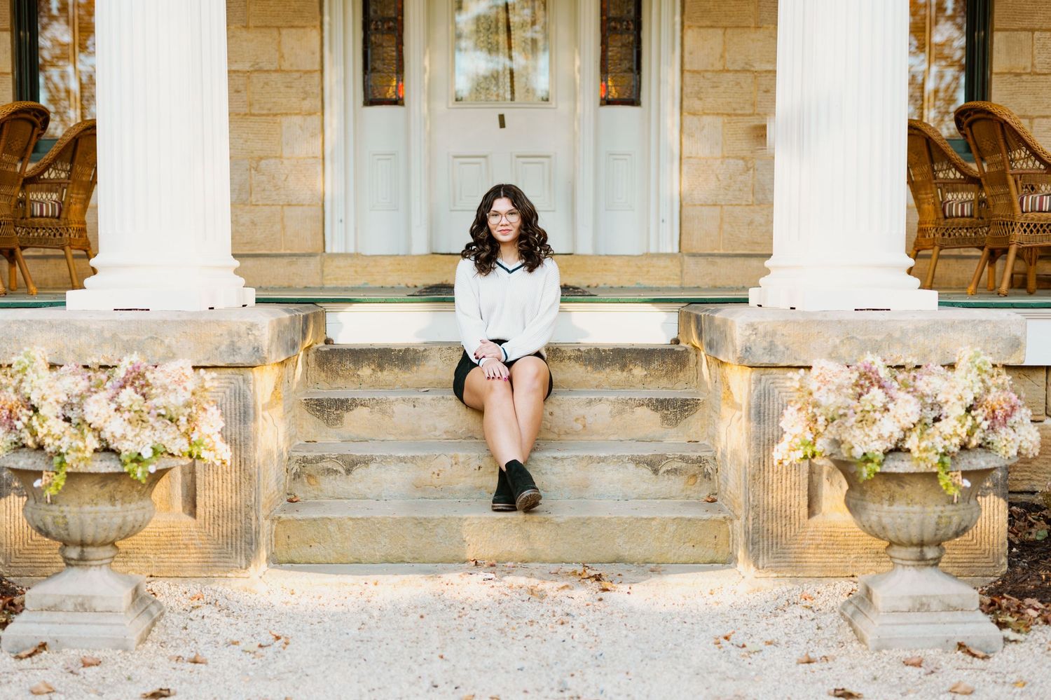 A photoshoot on historic stone steps of a building with classic architecture in warm lighting.