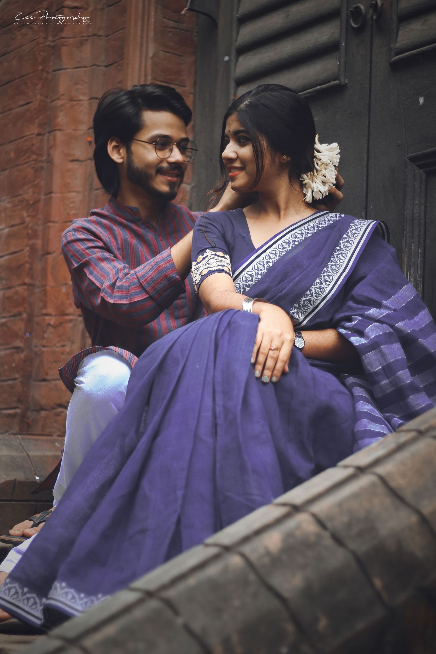 Couple in purple and plaid outfits share intimate moments during an urban photoshoot.