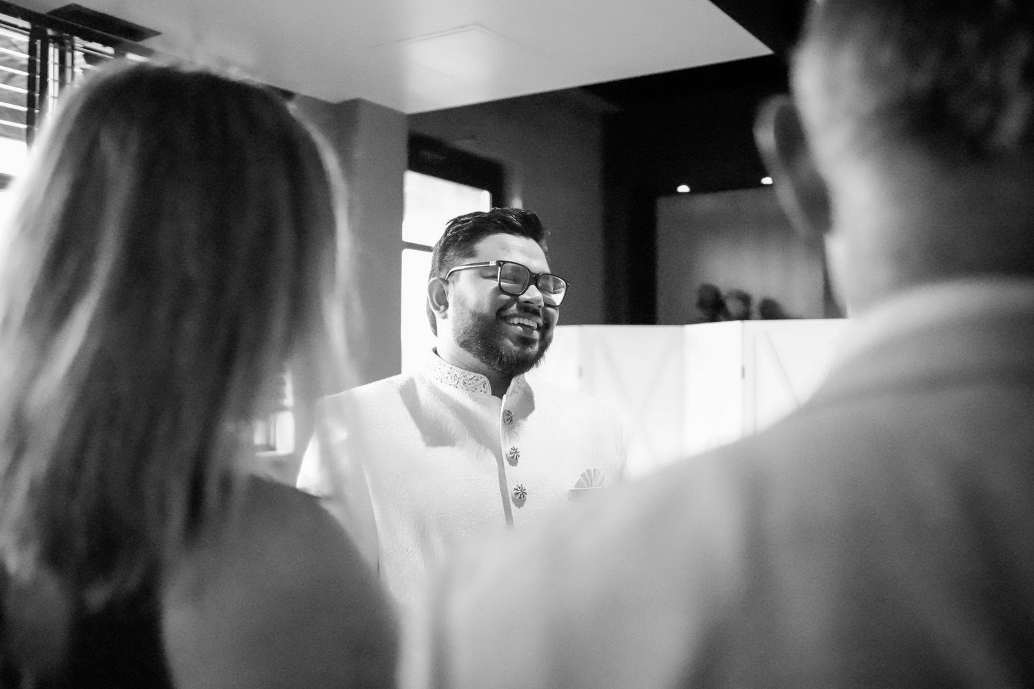 A series of five black and white wedding photos showing candid celebration moments and behind-the-scenes preparations.