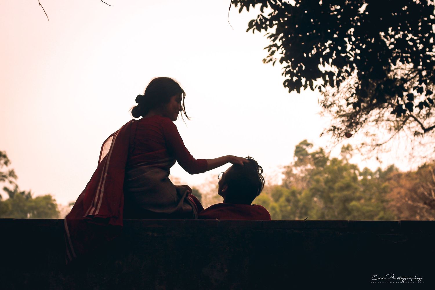 Silhouette of two people sharing an intimate moment at sunset.