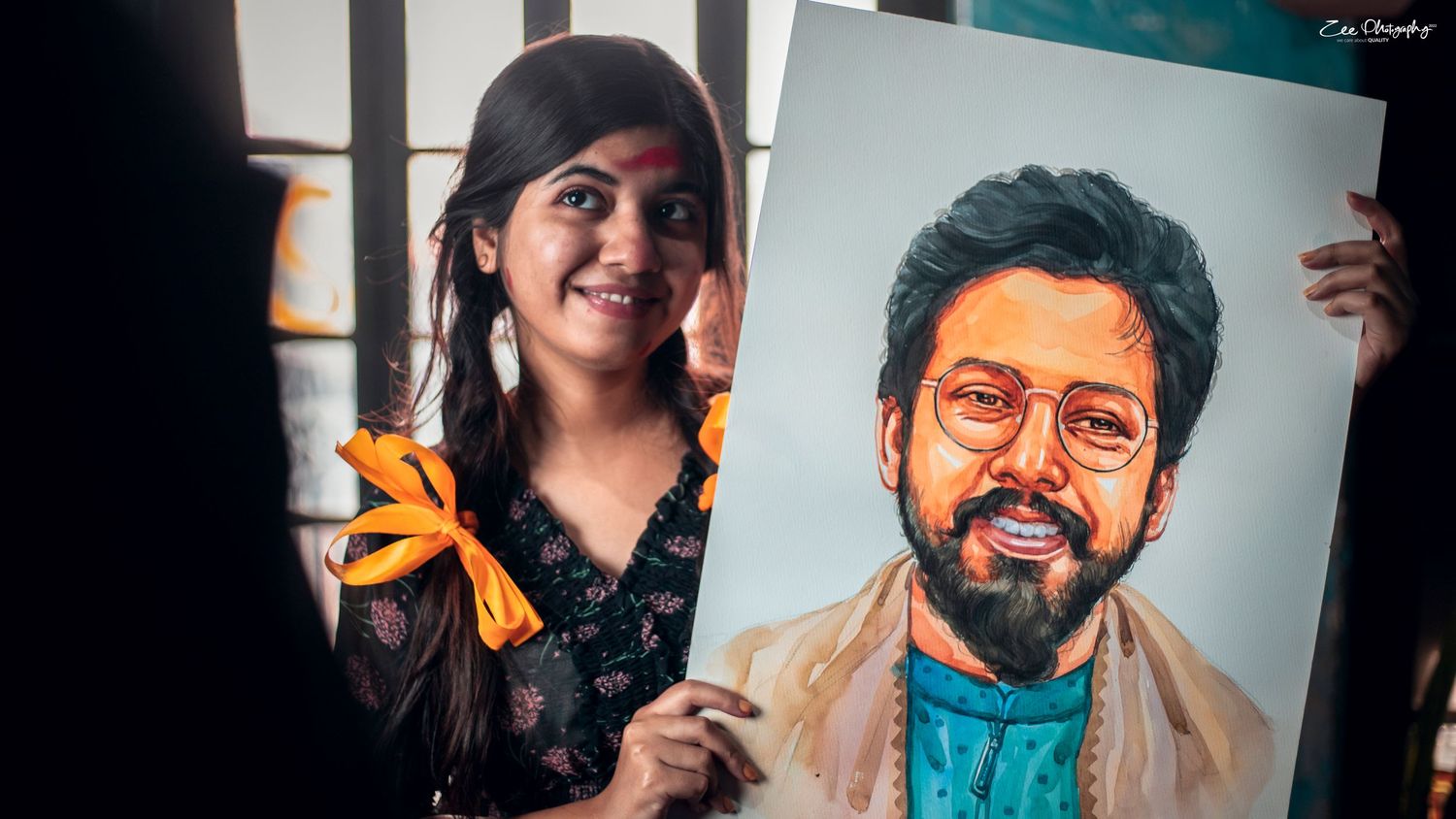 Artist displaying a colorful portrait artwork against a white background.