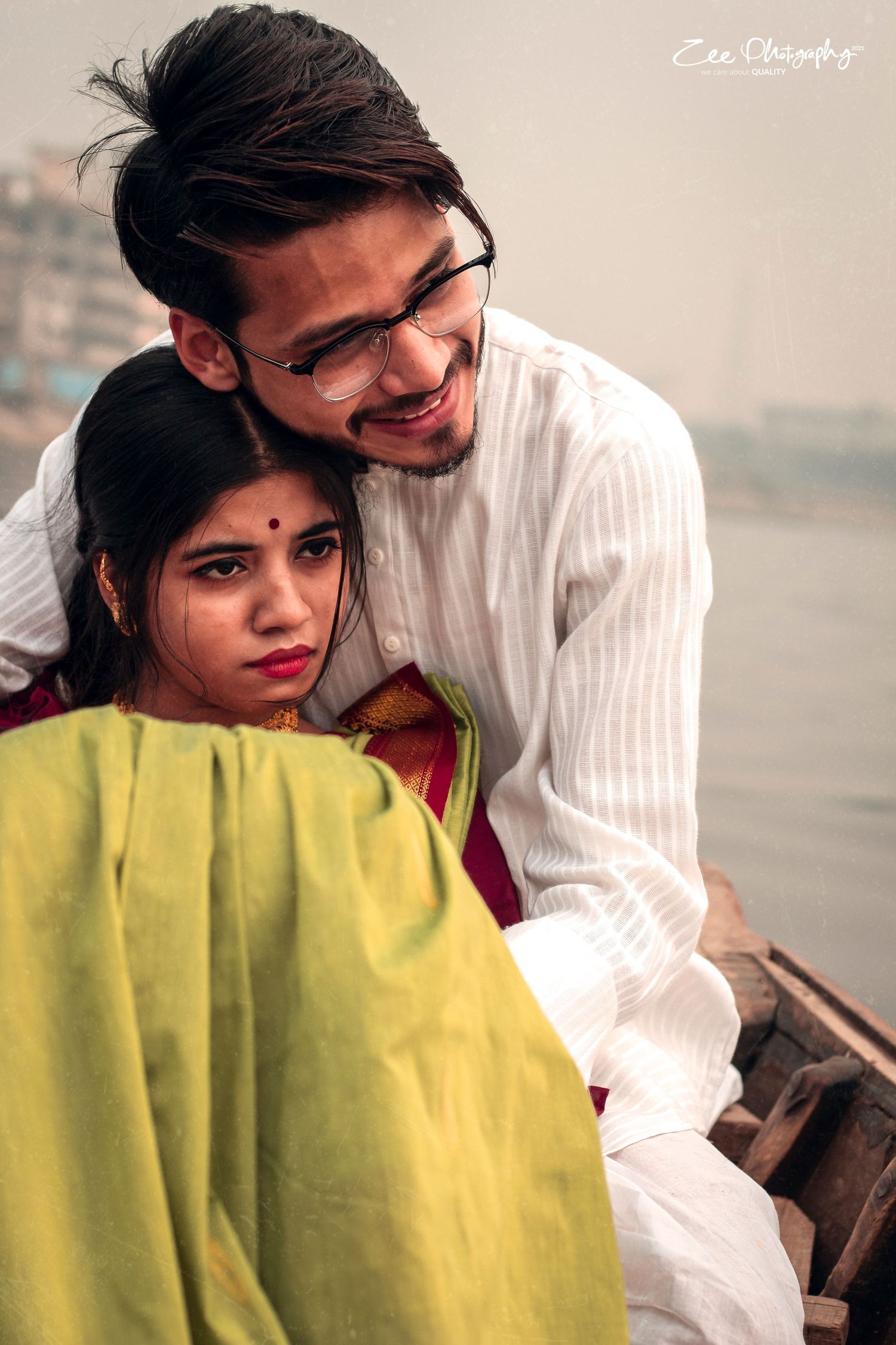 Couple in traditional Indian attire sharing a romantic moment on a boat.