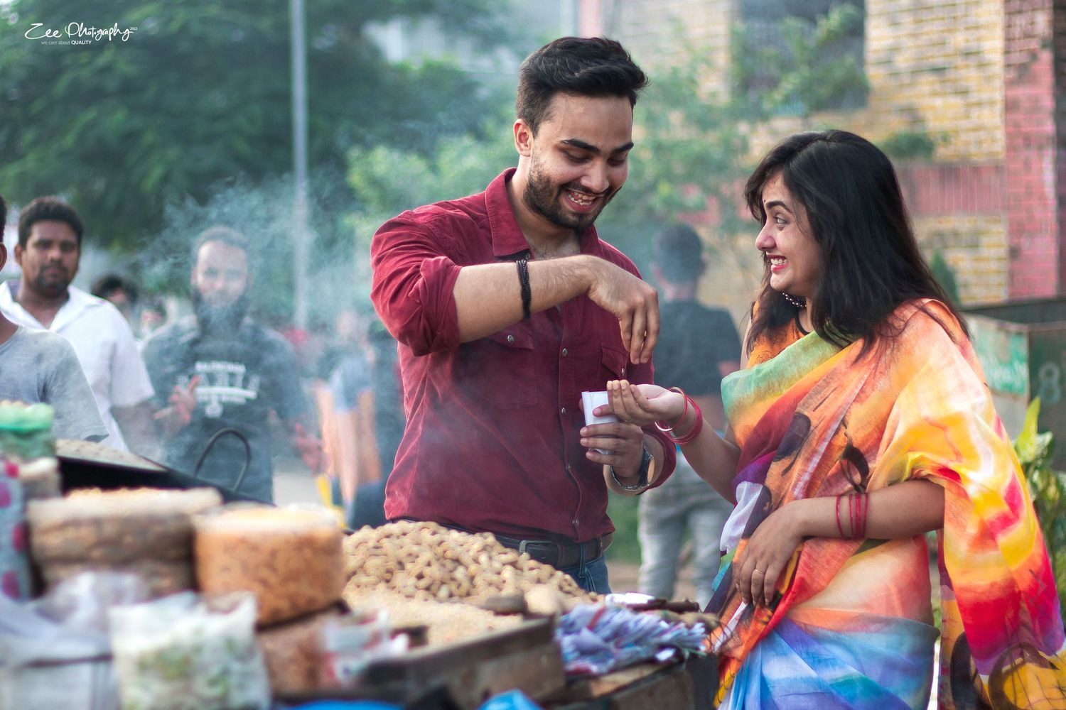 Colorful outdoor celebration with people enjoying festivities in bright clothing.