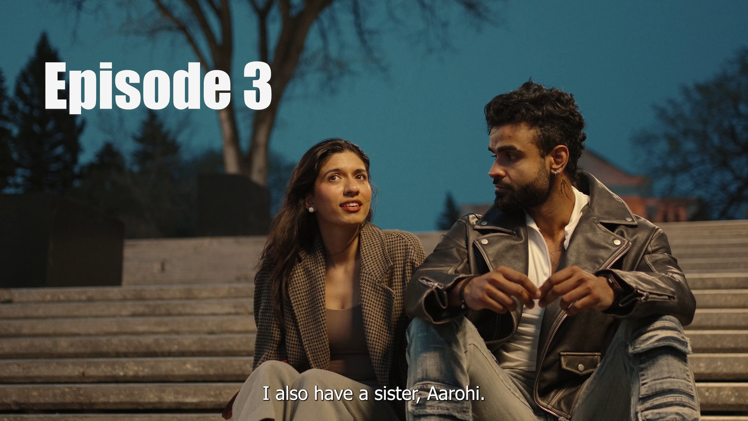 Two people in winter coats sit outdoors having a conversation in what appears to be episode 3 of a series.