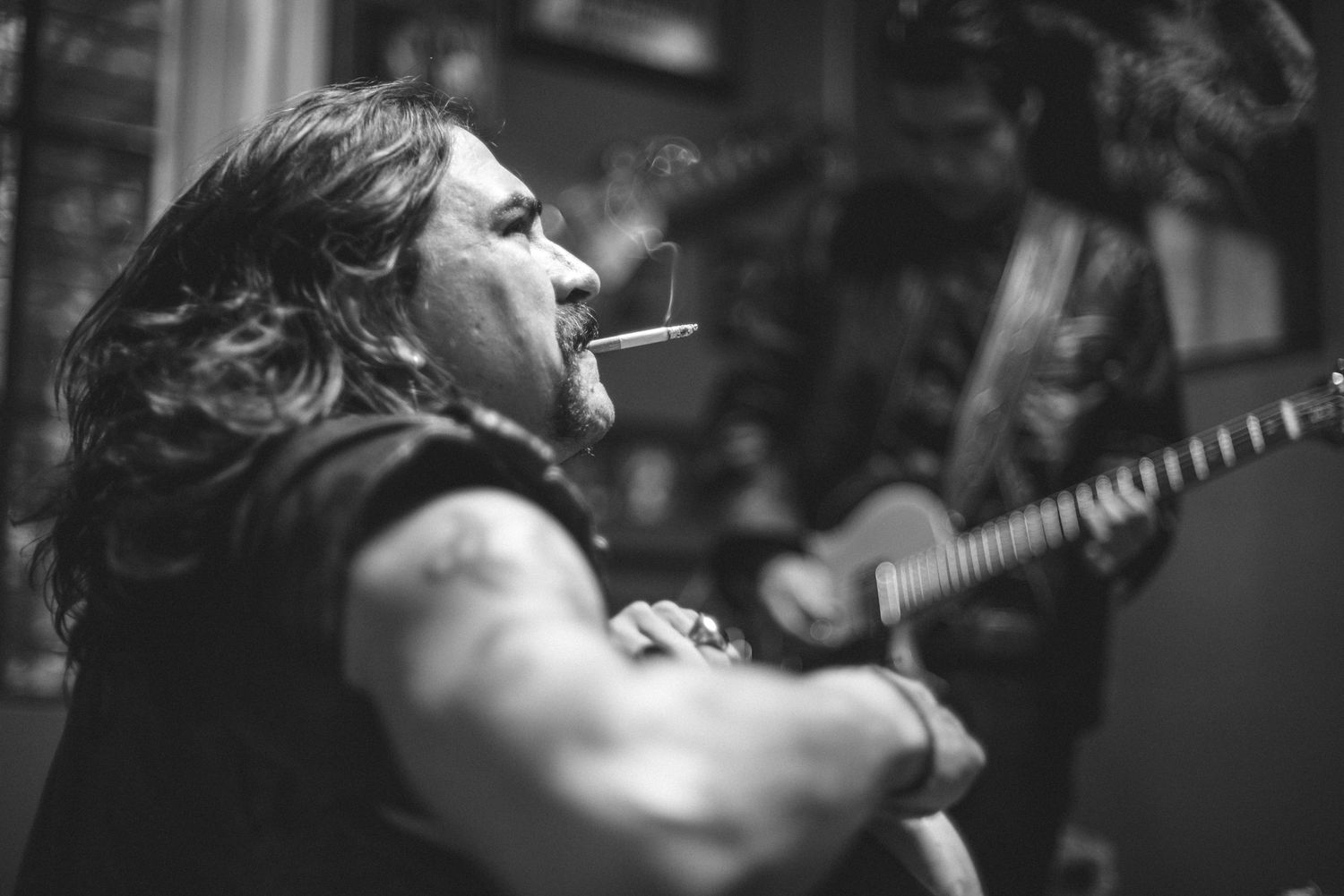 Dramatic black and white portrait of performer singing passionately on stage.
