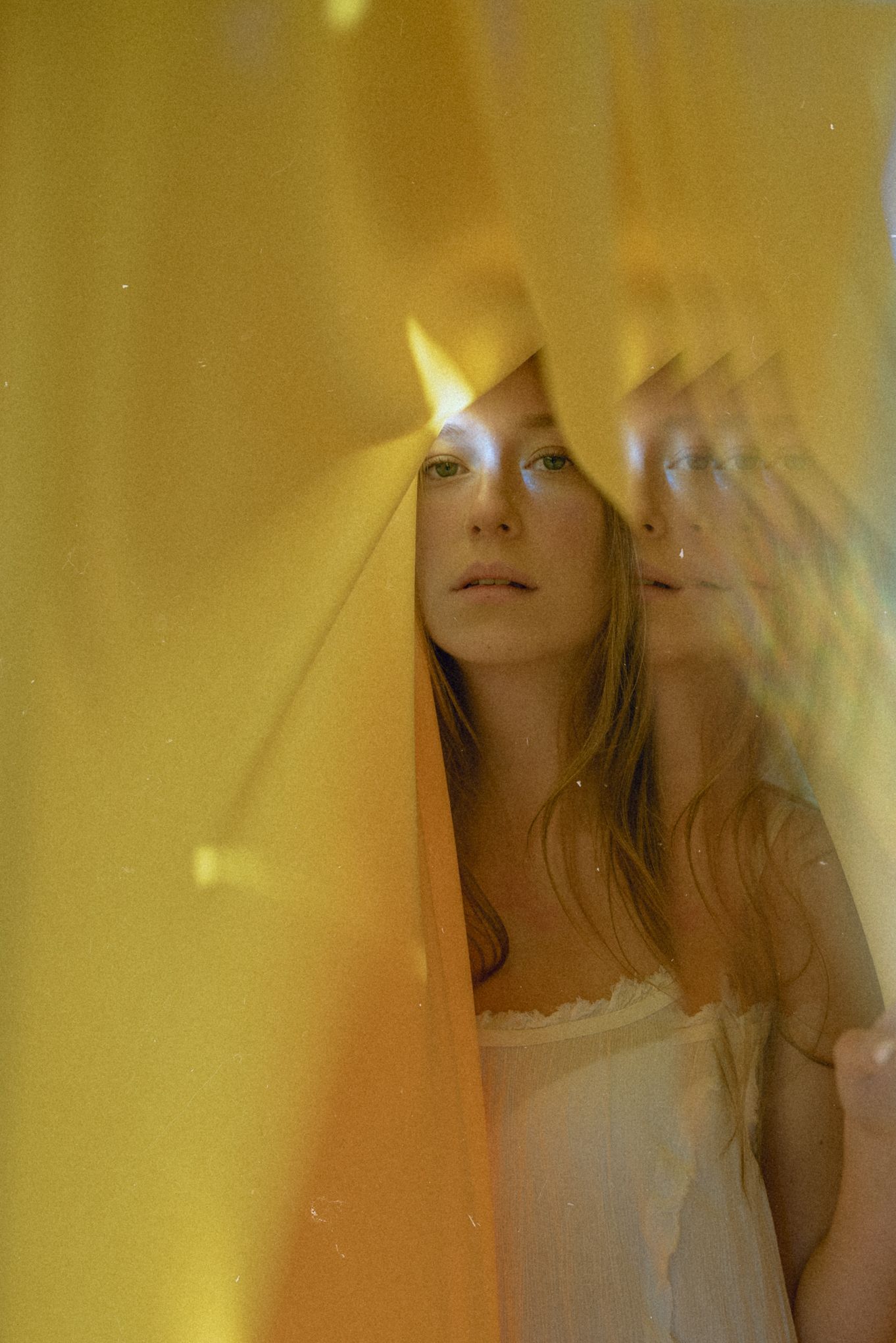 Dreamy double exposure portrait with golden light and prismatic effects.