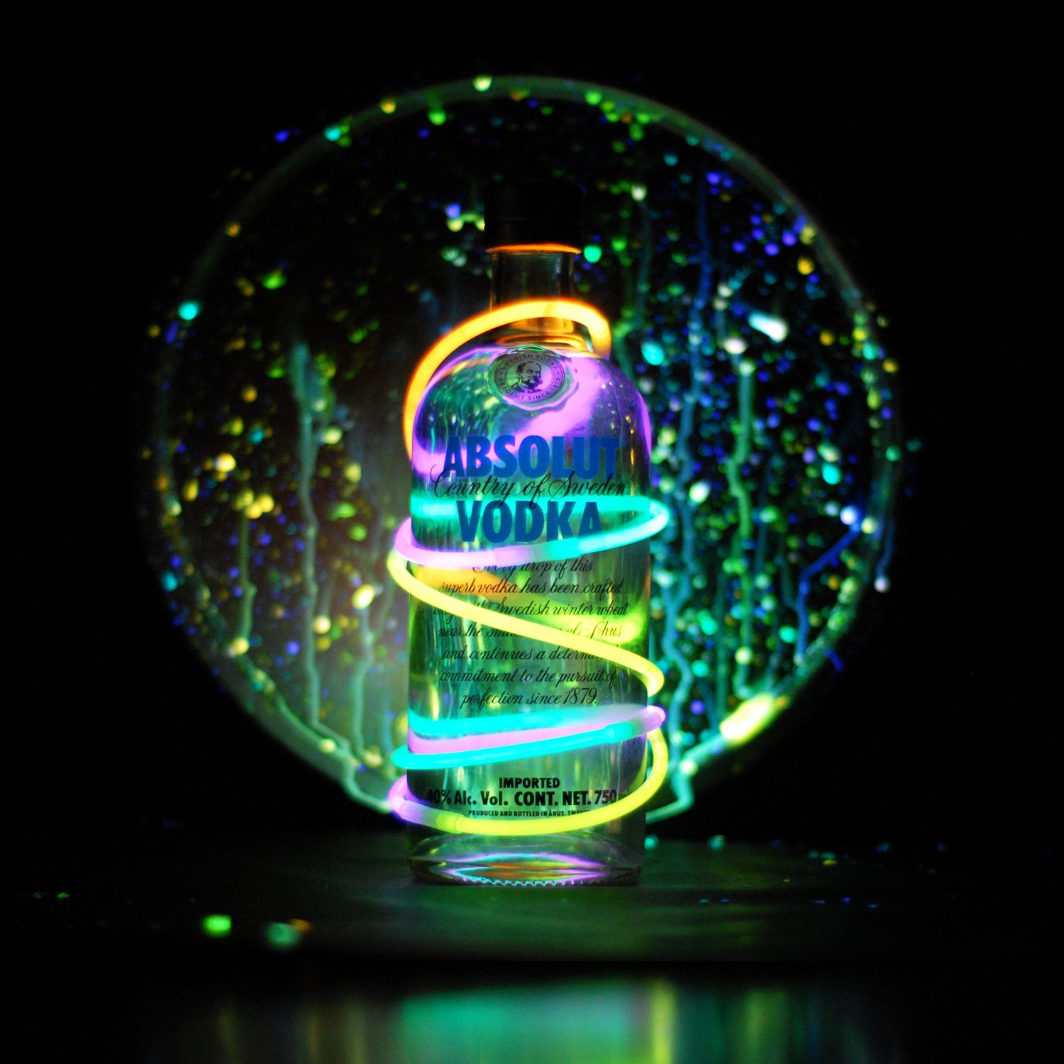 Multicolored light streaks create glowing spirals and patterns against a dark background in a long exposure photograph.