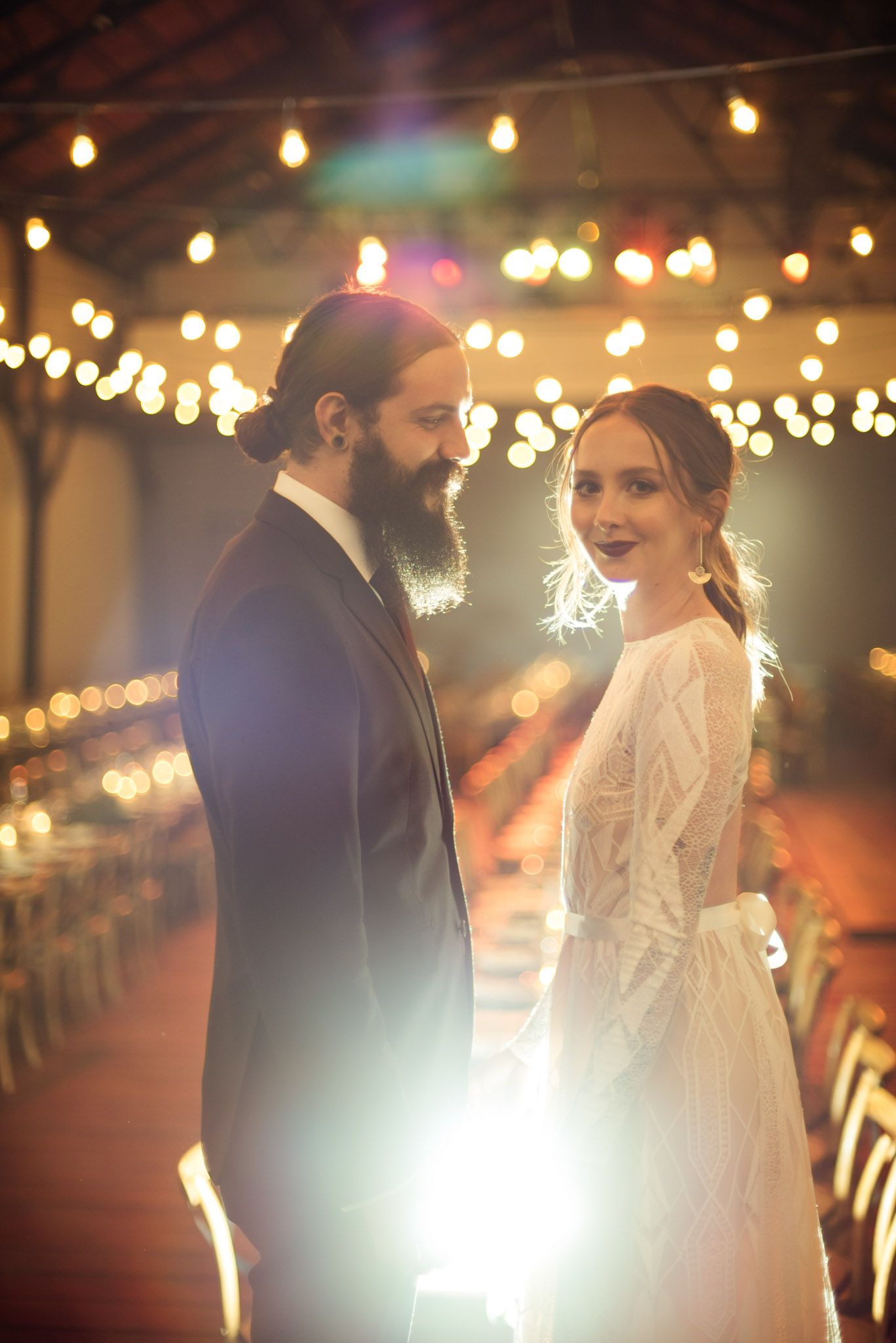 Romantic wedding venue glows with soft string lights as couple shares an intimate moment on their special evening.