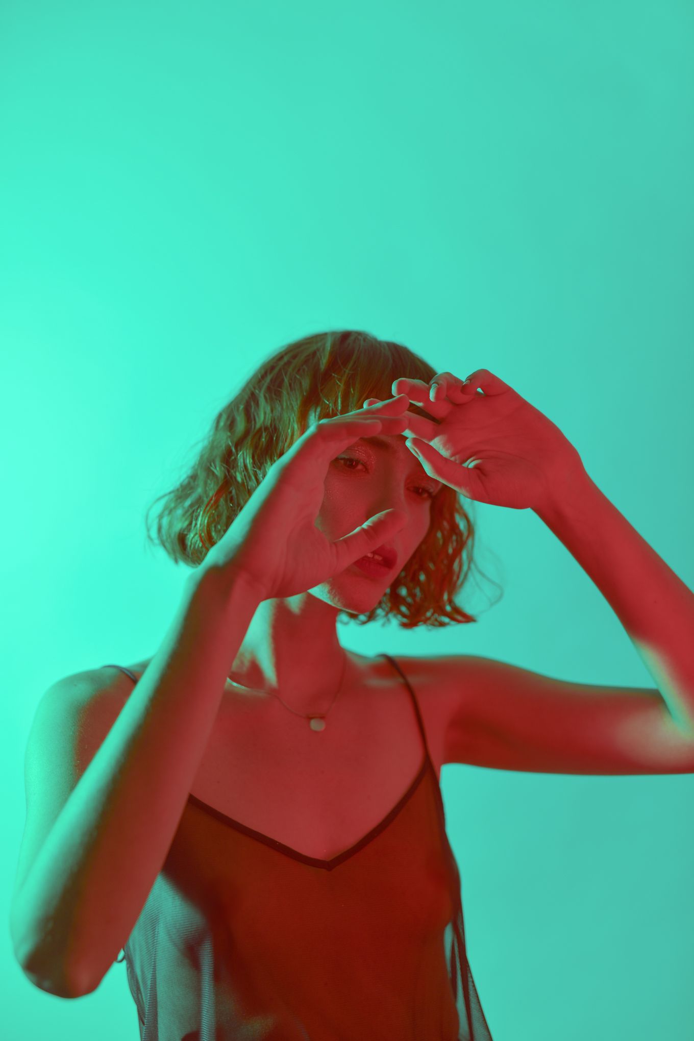 Artistic portrait with vibrant red and turquoise color overlay.