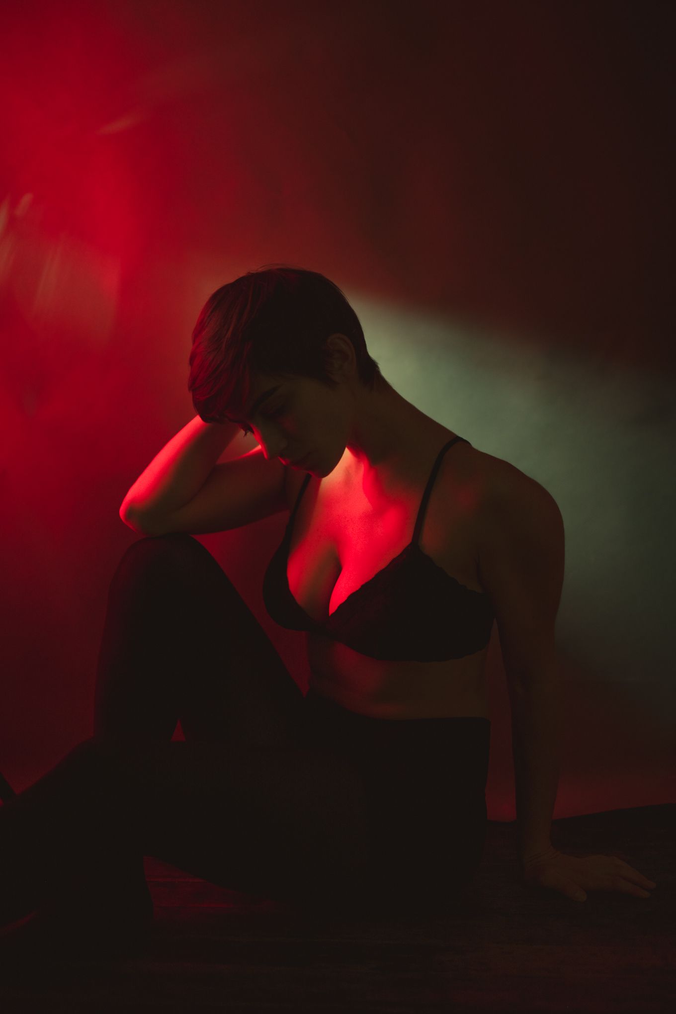 Silhouetted figure in intimate pose against red and green mood lighting.