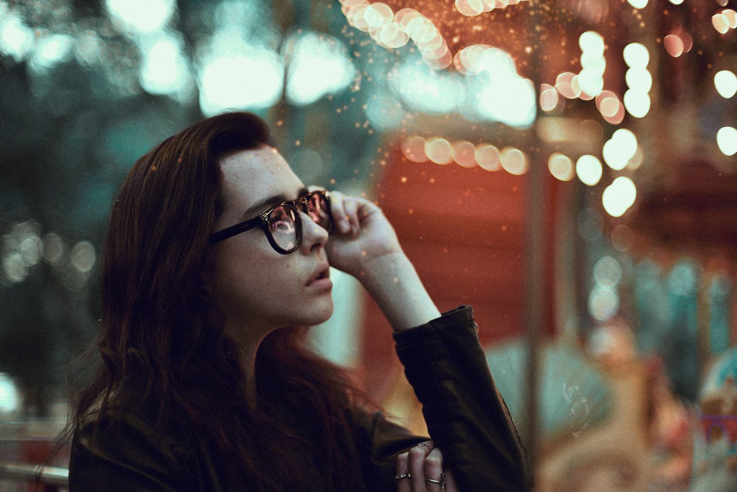 Portrait of person in glasses with bokeh lights in twilight atmosphere.