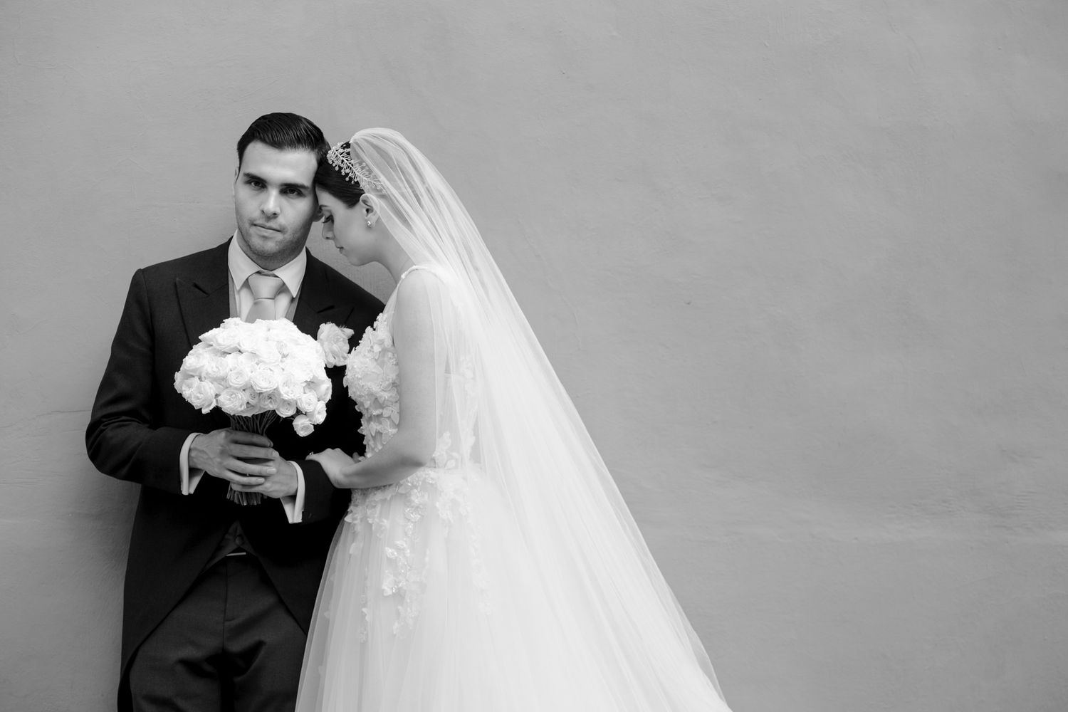 A black and white wedding portrait with a bouquet of white flowers.
