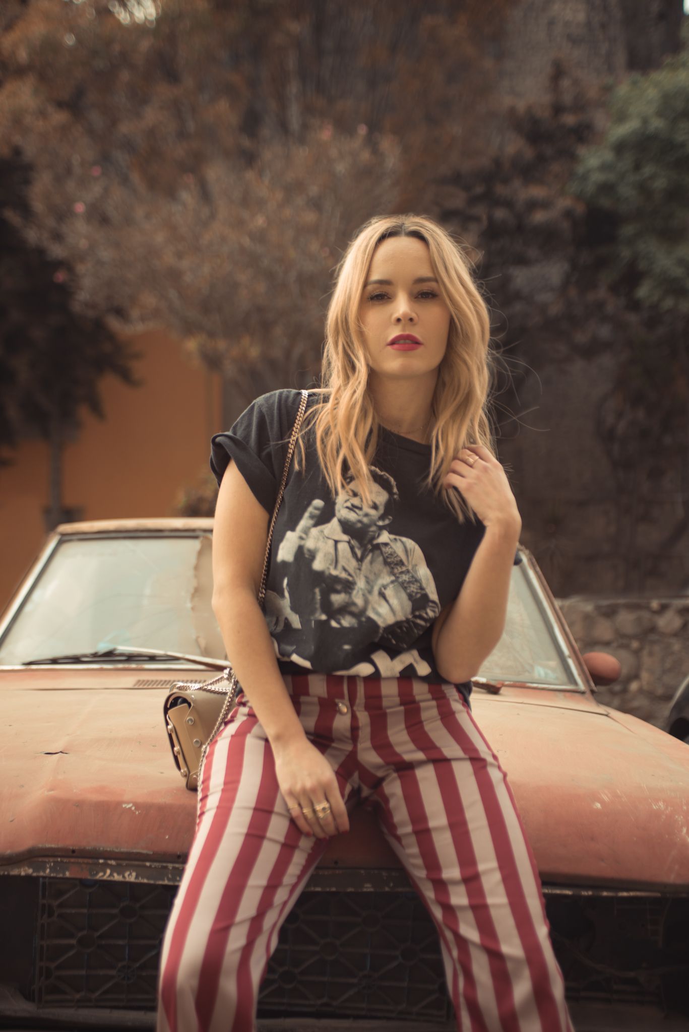 Vintage-inspired fashion shoot with classic car and red striped pants.