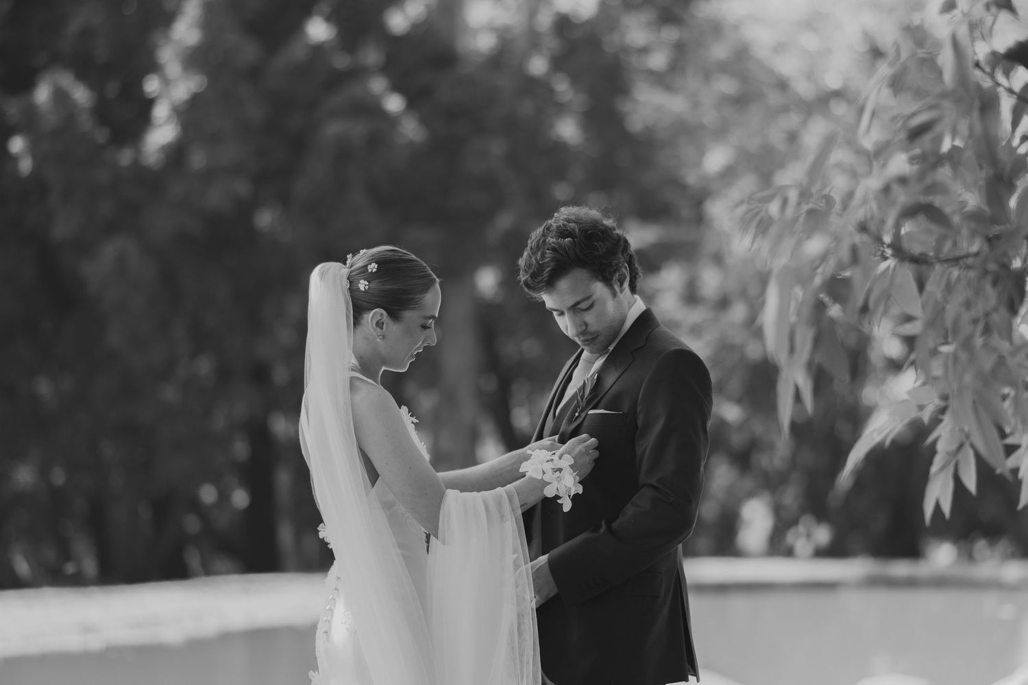 Couple exchanges rings during intimate outdoor ceremony in black and white.